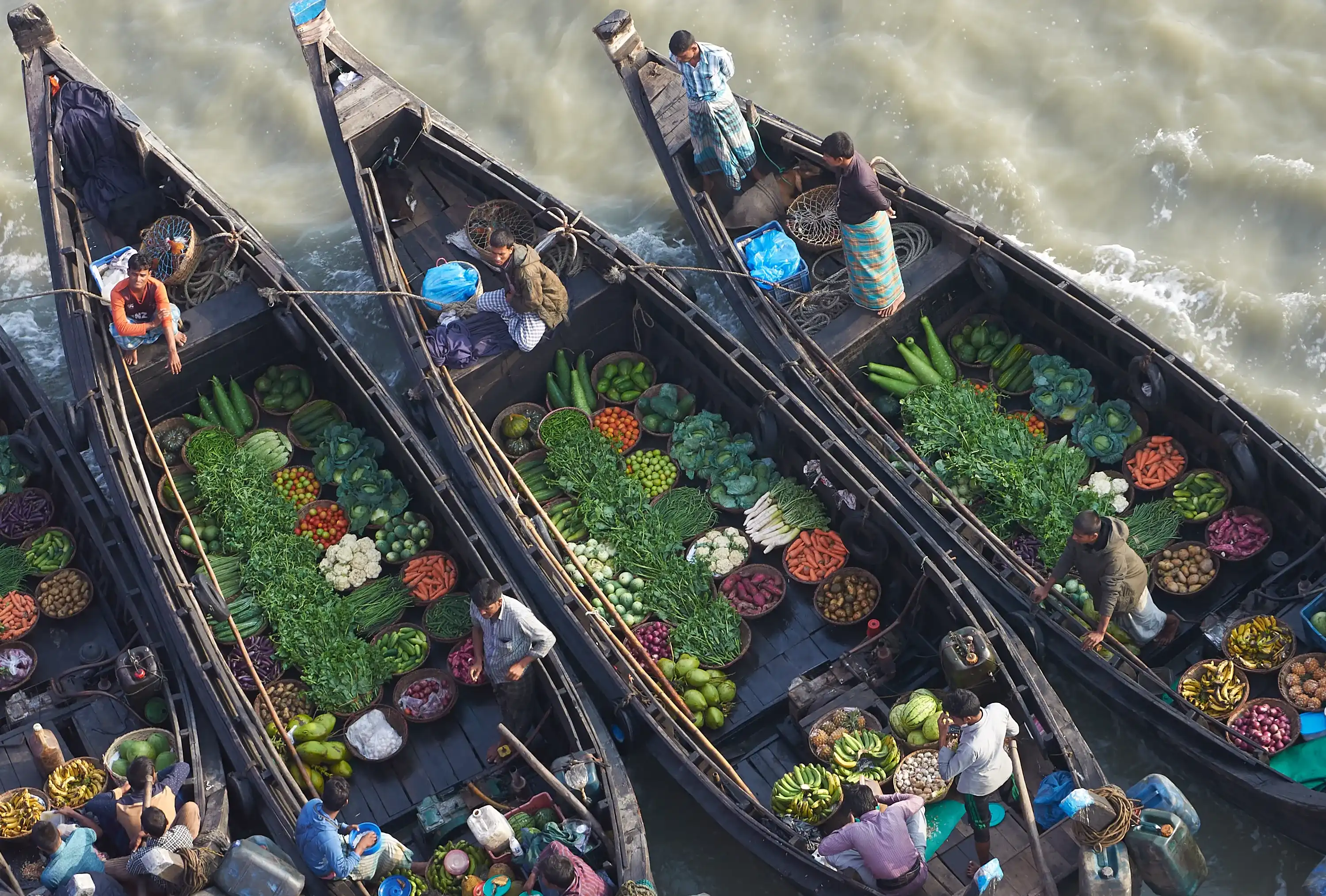 Chittagong / Bangladesh - 13 March 2017: Floating bazar in Bangladesh, salesmen offering food, fresh vegetables, meat. Chittagong / Bangladesh - 13 March 2017: Floating bazar in Bangladesh, salesmen offering food, fresh vegetables, meat.
