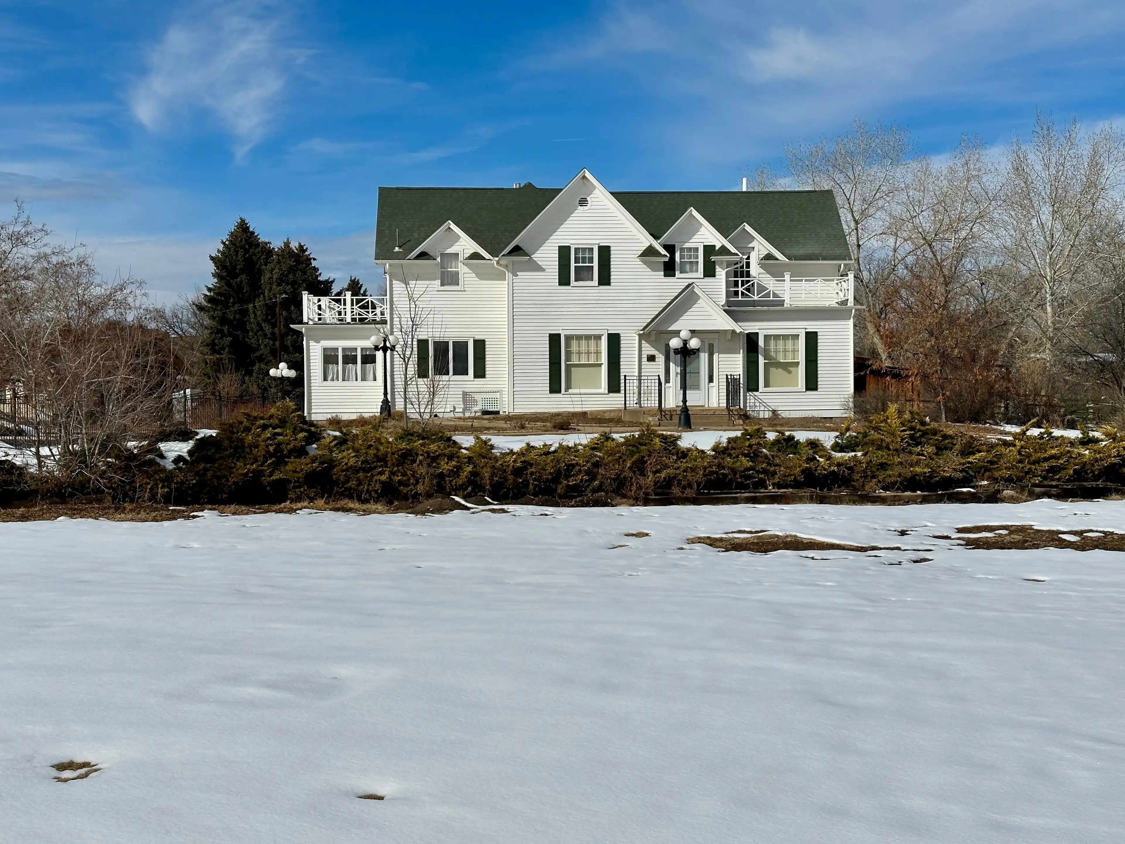 Greeley, Colorado, USA - February 18, 2024: House with large yard covered with snow. Located at The Centennial Village Museum. Greeley, Colorado, USA - February 18, 2024: House with large yard covered with snow. Located at The Centennial Village Museum.
