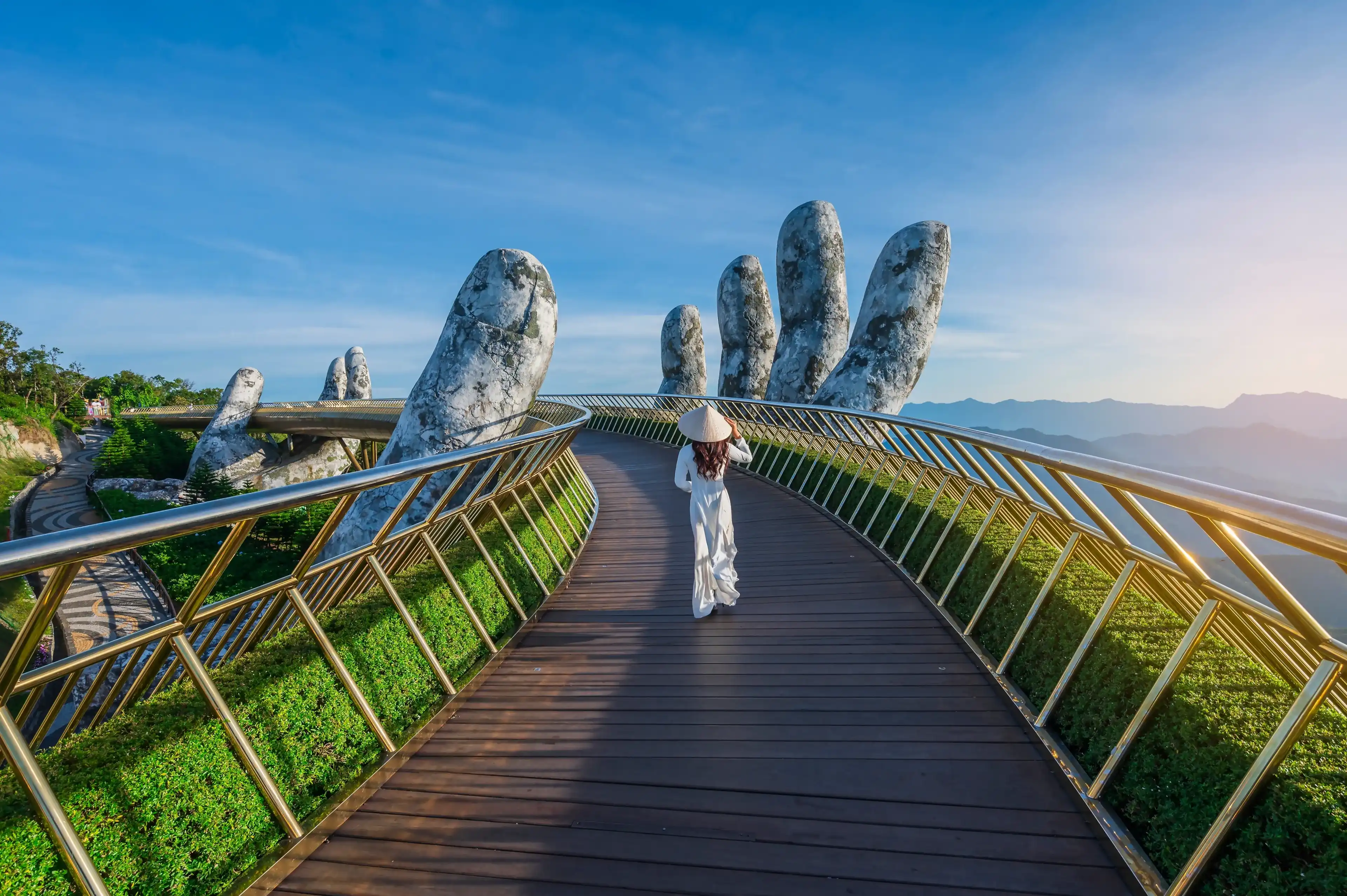 Vietnamese girl with traditional dress (ao dai) on Golden bridge at the top of the Ba Na Hills, Vietnam Vietnamese girl with traditional dress (ao dai) on Golden bridge at the top of the Ba Na Hills, Vietnam