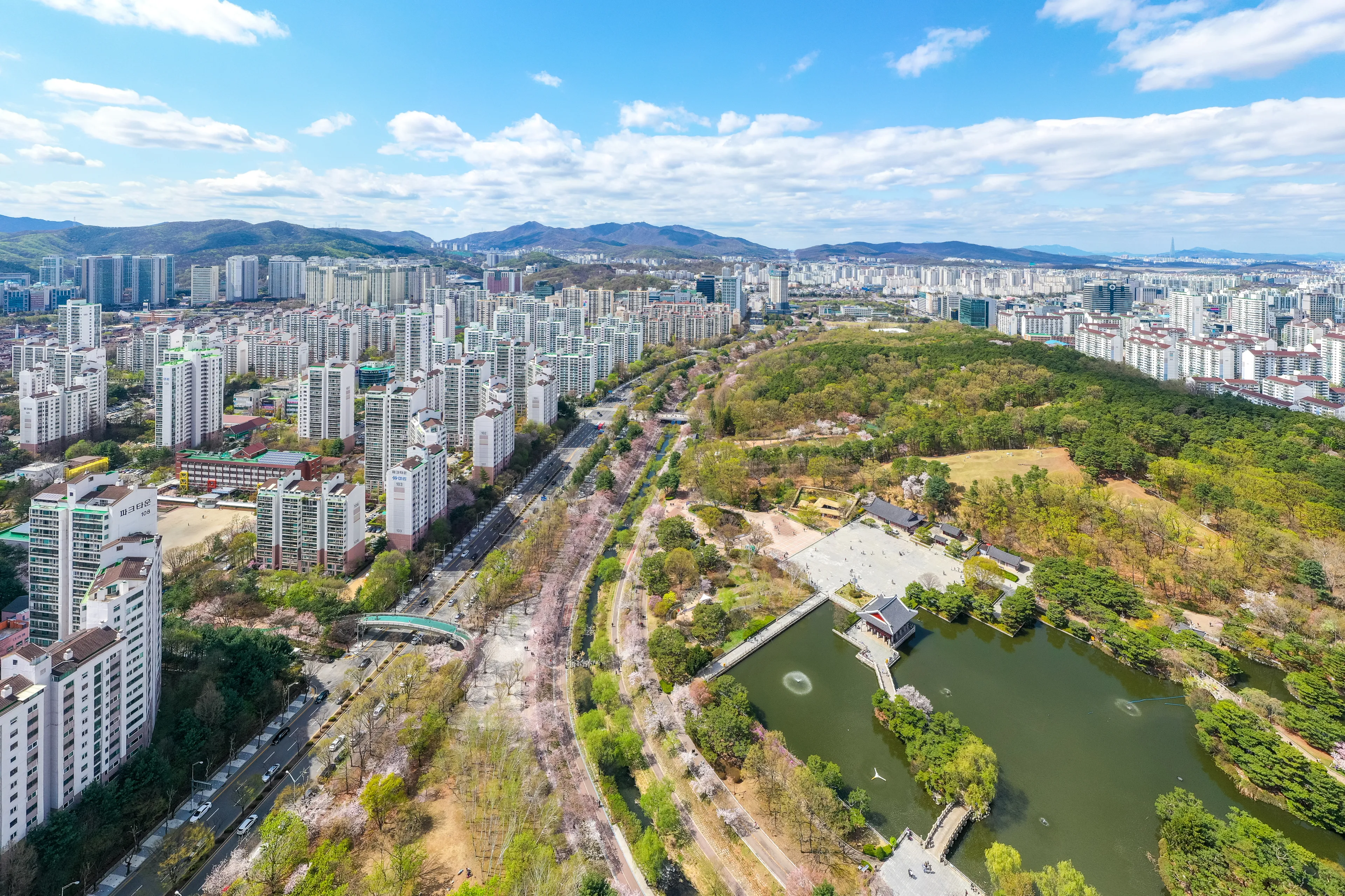 Bundang-gu, Seongnam-si, Gyeonggi-do, South Korea - April 4, 2021: Aerial and spring view of high-rise apartments with lake and mountain 