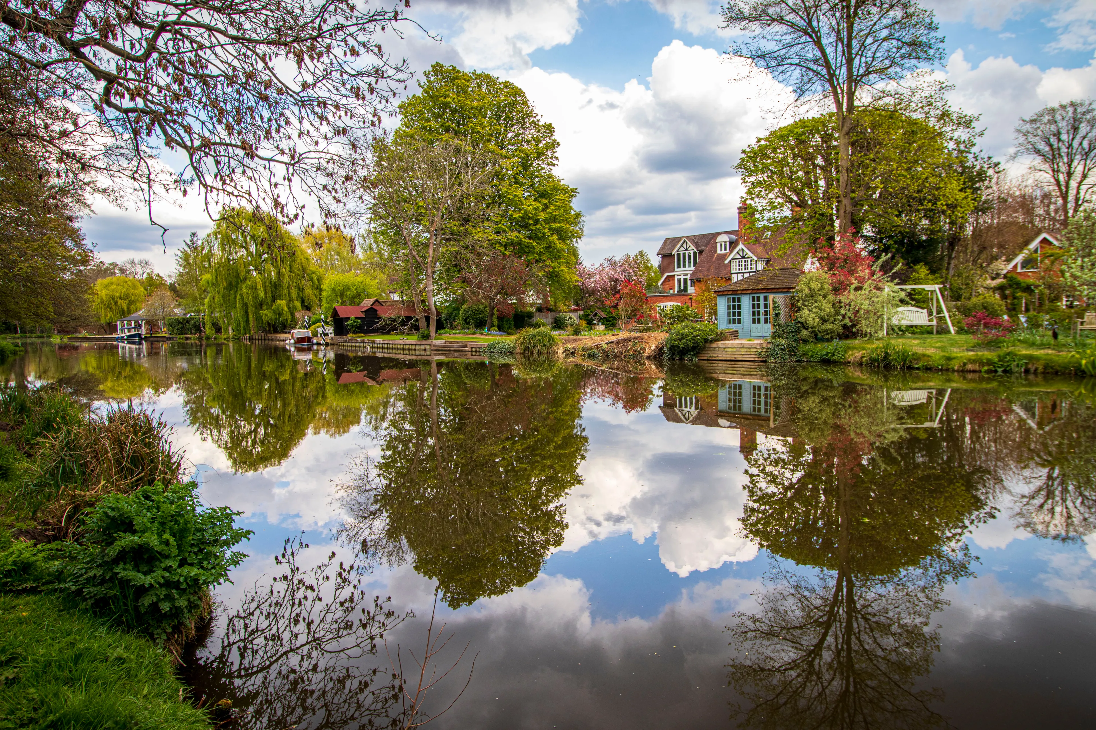 Beautiful England.View of houses and boats reflected in Wey river water. Weybridge 01 04 2021 