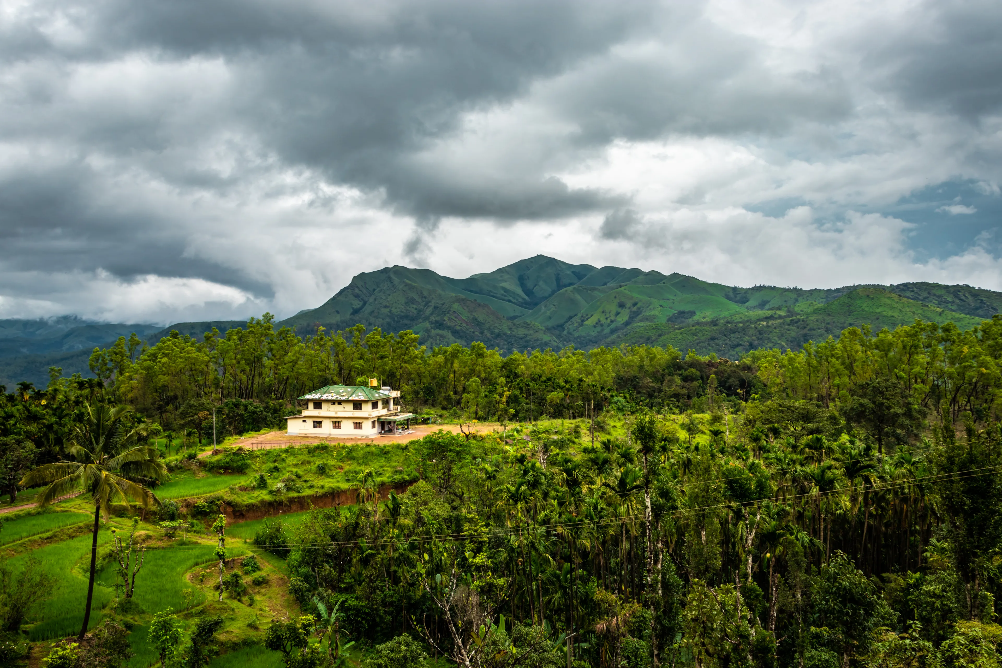 house at remote village isolated with mountain coverd clouds and green forests image is showing the amazing beauty and art of nature. This image is taken at karnataka india.
