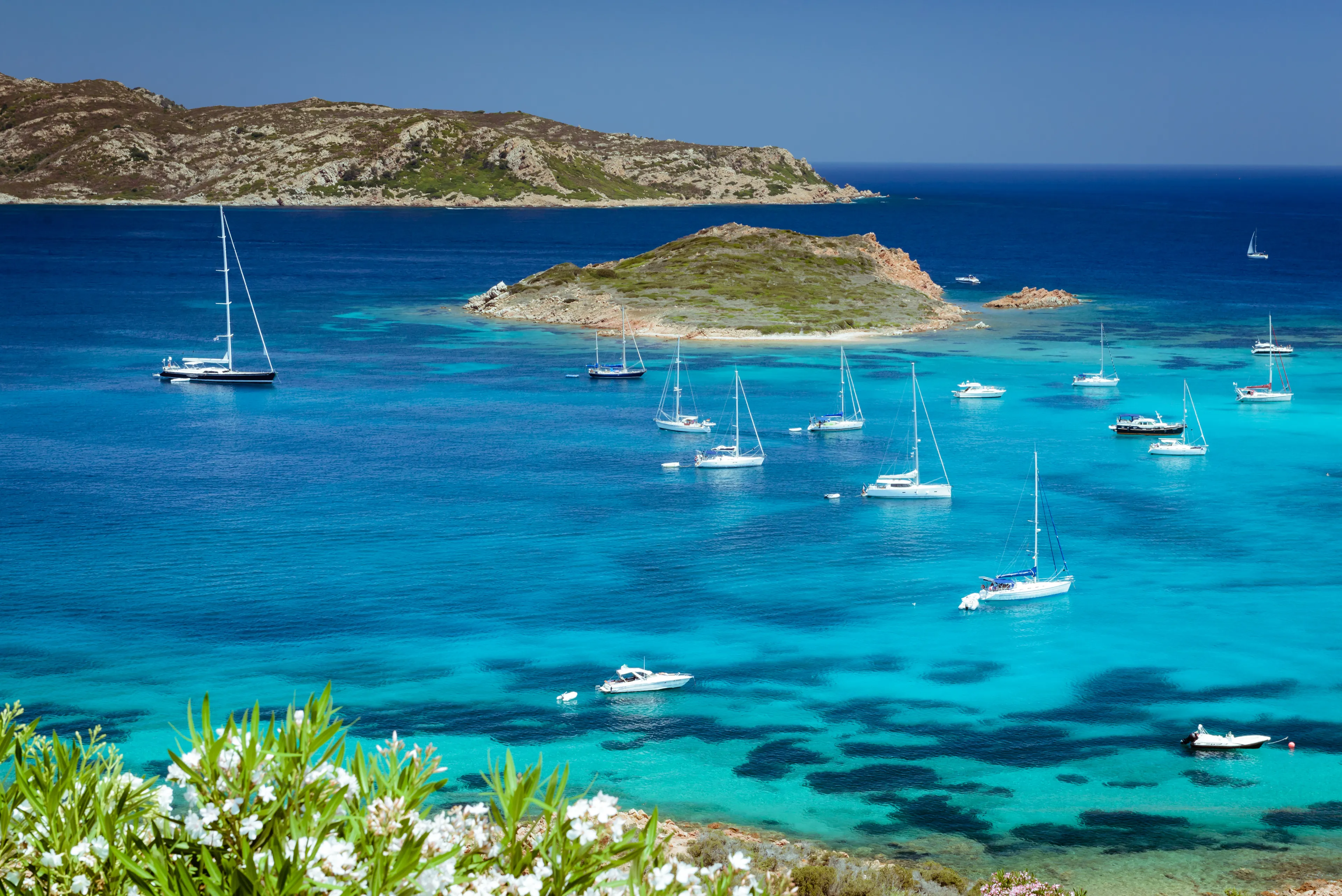 Clear see water, yachts and boats on Capo Coda Cavallo Beach (Tail of the horse), San Teodoro, Sardinia Island, Italy