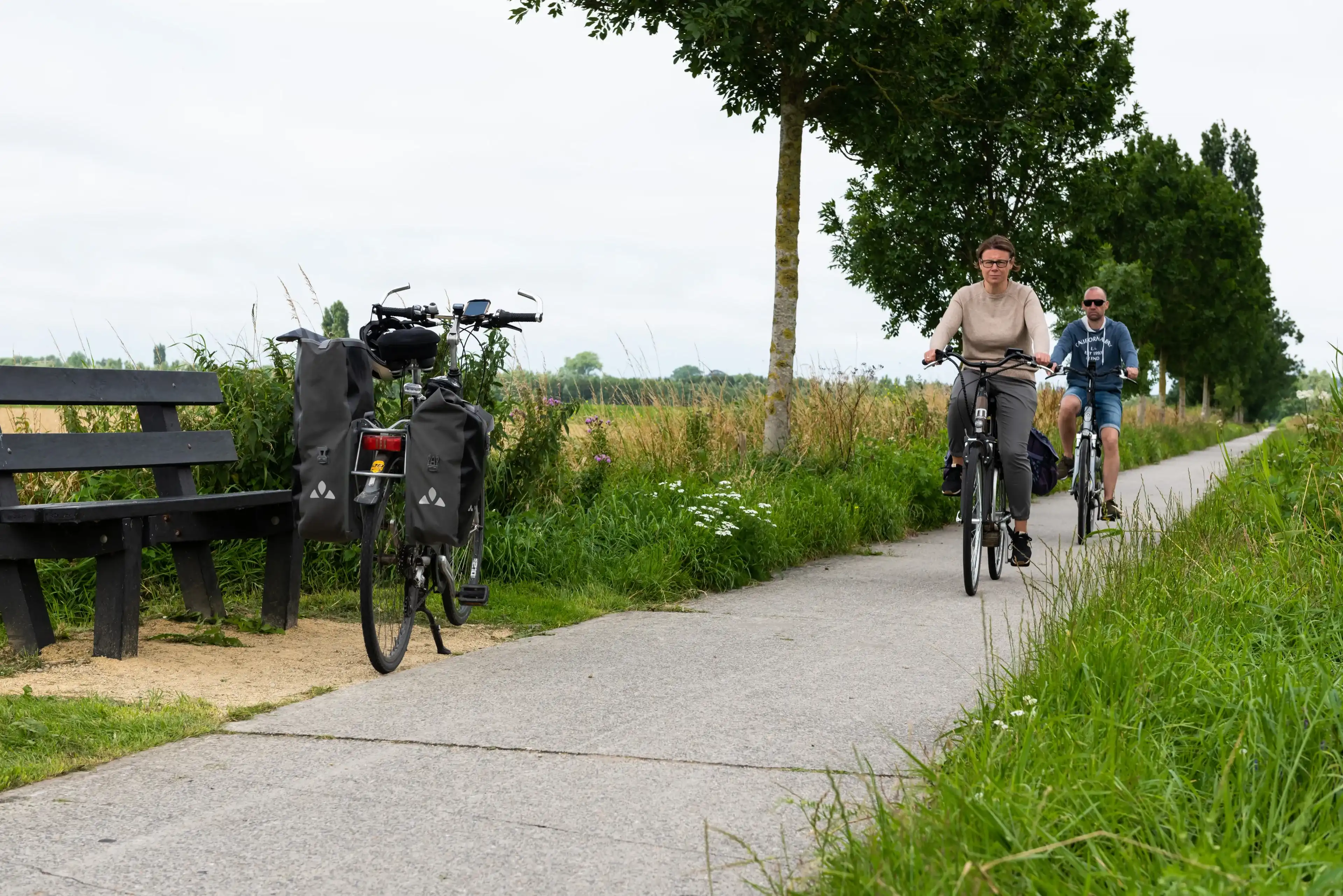 Veurne, West Flanders Region - Belgium - 07 18 2021 Recreative cycling path with biking couple Veurne, West Flanders Region - Belgium - 07 18 2021 Recreative cycling path with biking couple