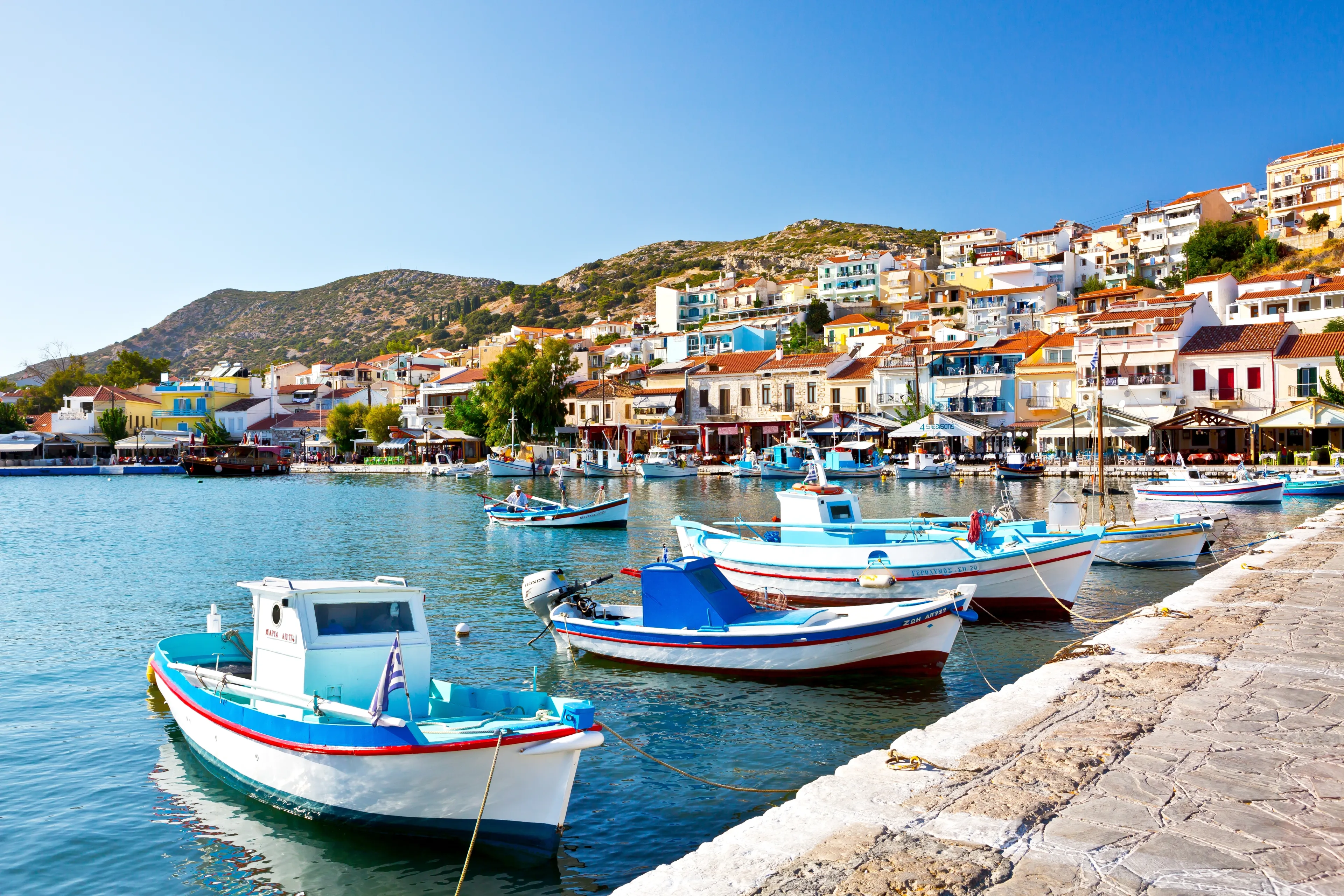 PYTHAGOREIO, SAMOS, GREECE - SEPTEMBER 13, 2017: Typical colourful fishing boat in Pythagorion port. Beautiful Pythagorion Town in Samos Island.