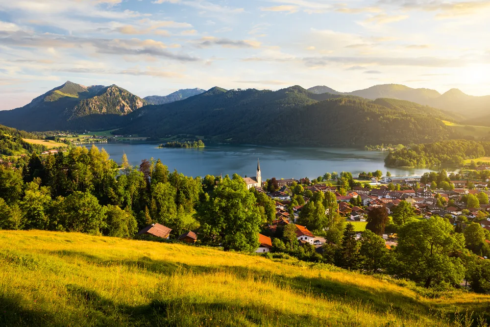 View of mountains and mountain lake during sunset in summer. Beautiful town of Schliersee in Bavaria, Germany, Europe.