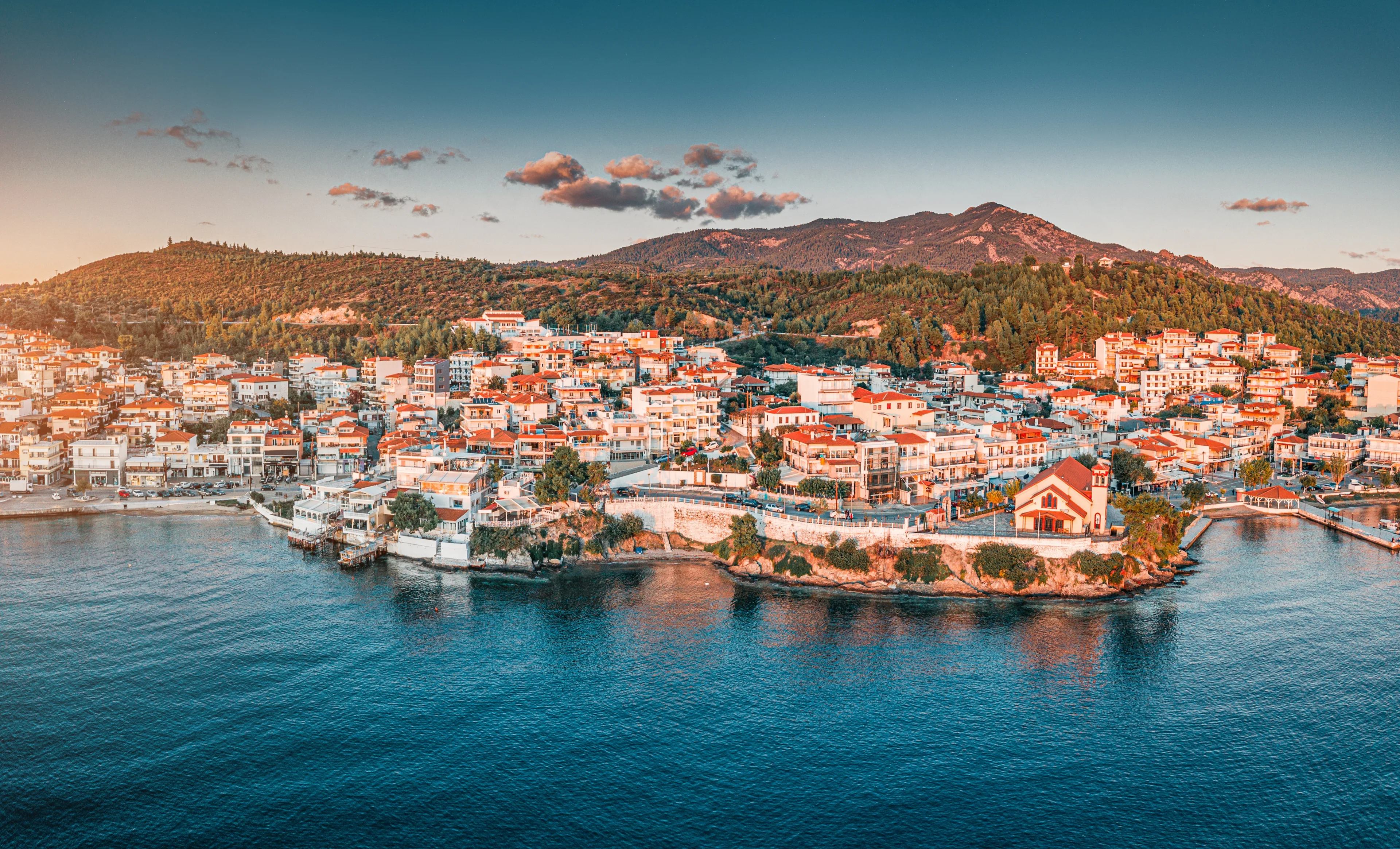 Orthodox Church of Taxiarch Angels among Houses and villas in a resort town Neos Marmaras in Sithonia, Halkidiki, Greece