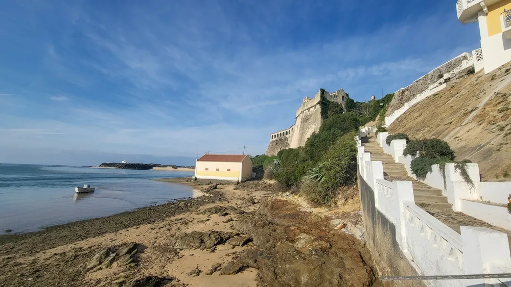 View of Medieval Fort Forte De Sao Clemente Over the Mira River With Small Boat in Sunny Day With Clear Blue Sky. Vila Nova De Milfontes, Portugal, Rota Vicentina Coast. The Fisherman Trail