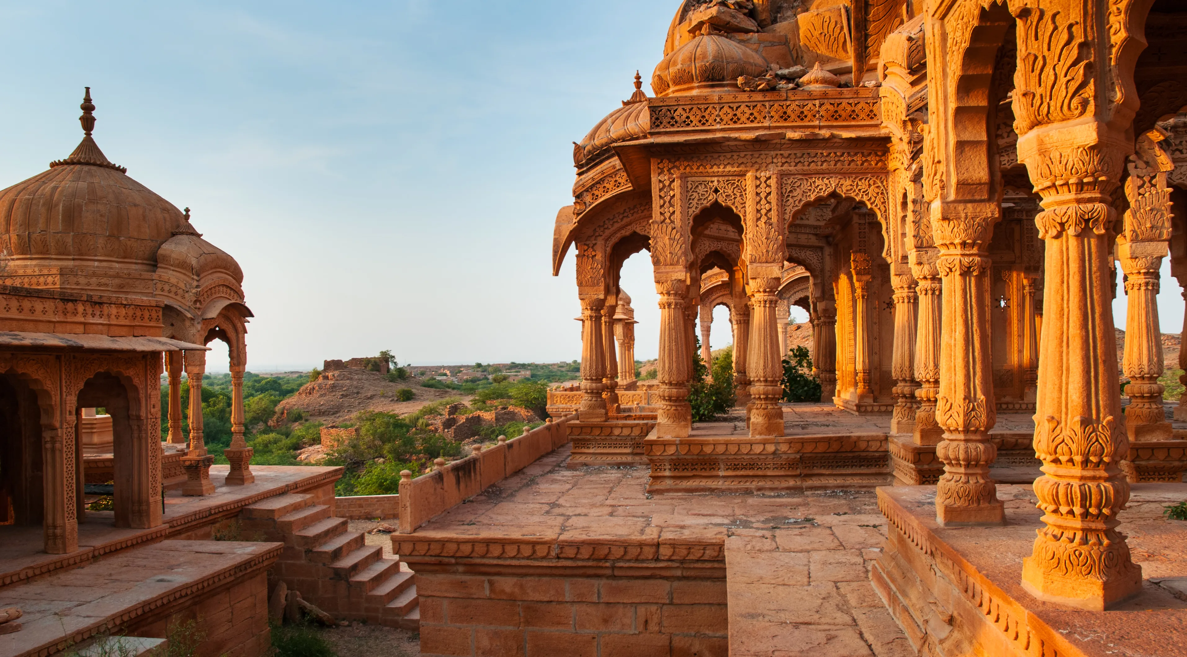 The royal cenotaphs of historic rulers, also known as Jaisalmer Chhatris, at Bada Bagh in Jaisalmer, Rajasthan, India. Cenotaphs made of yellow sandstone at sunset