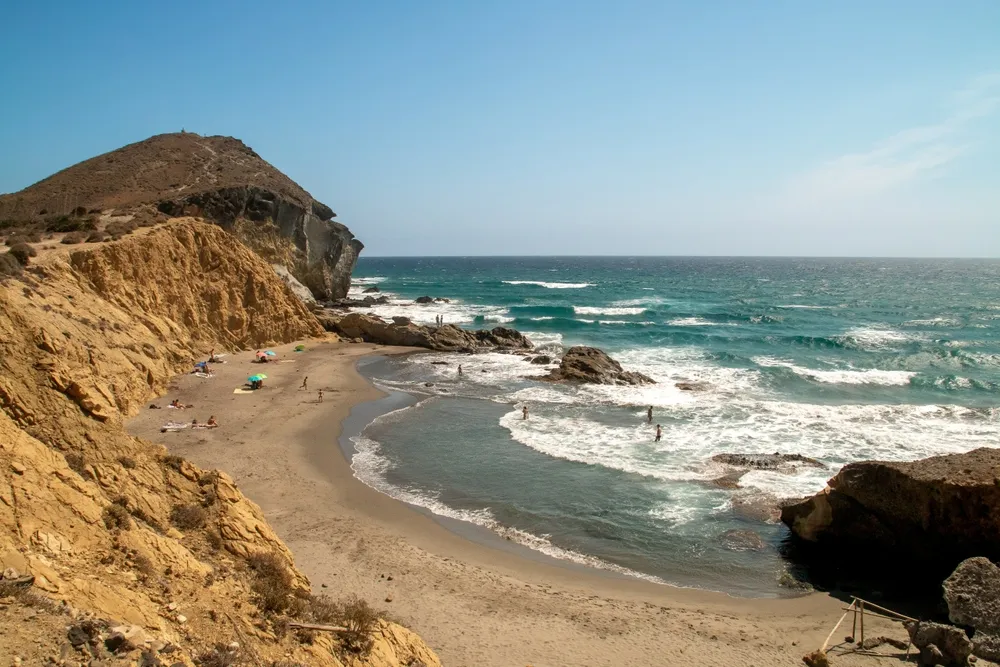 Bathers in Los Amarillos cove in the Mediterranean Sea. Small beach next to Genoveses beach at the end of summer. Nijar, Spain.