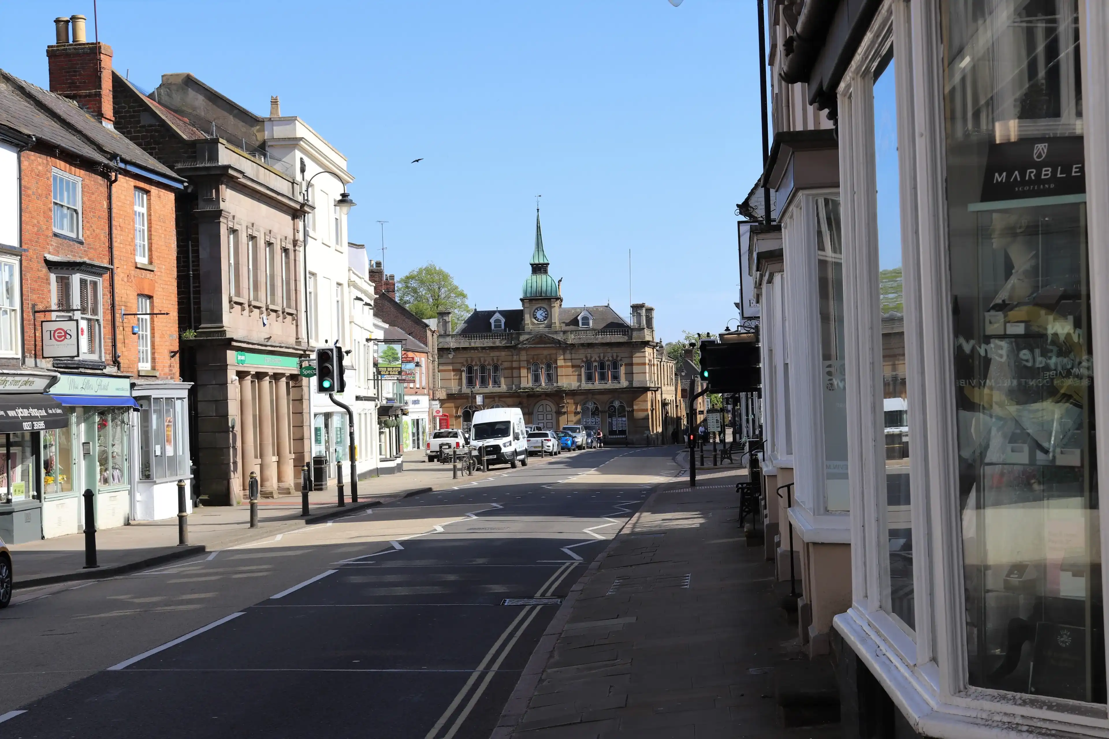 Towcester, Northamptonshire, England - April 21st 2020: Deserted High Street at Towcester during the Covid-19 lockdown of 2020. Empty road and shops at popular market town, deserted during lockdown. Towcester, Northamptonshire, England - April 21st 2020: Deserted High Street at Towcester during the Covid-19 lockdown of 2020. Empty road and shops at popular market town, deserted during lockdown.