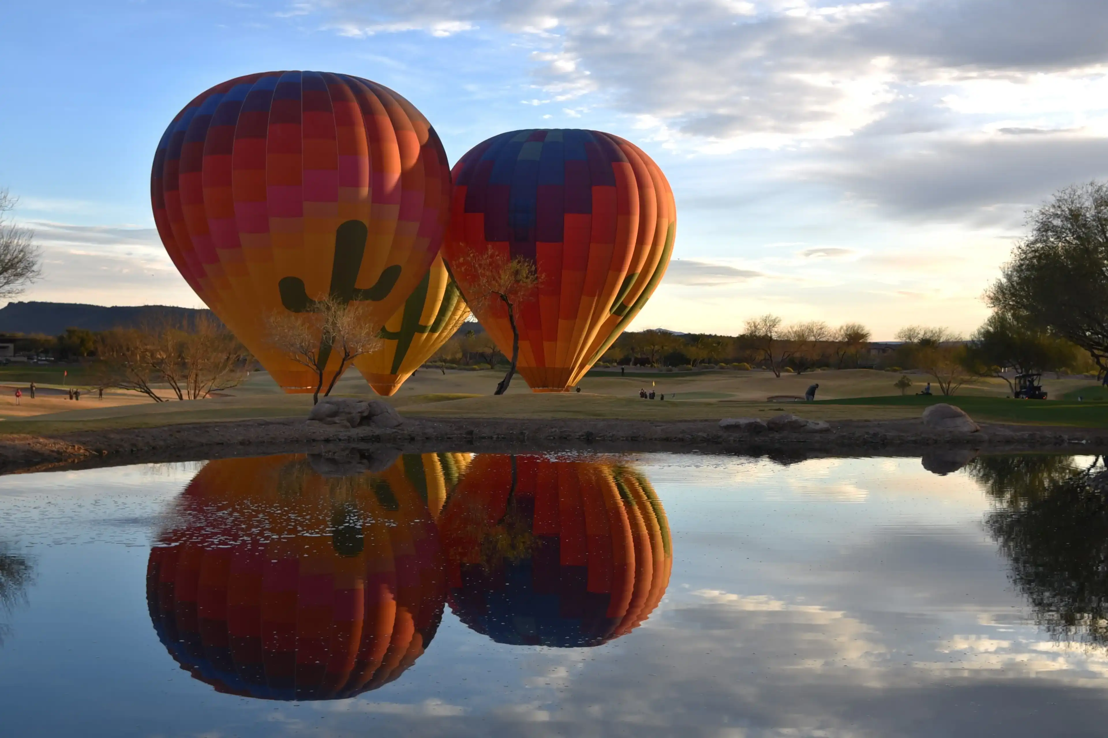 Peoria Arizona 3-6-2023 Hot air balloons being readied for flight with reflection in a lake Peoria Arizona 3-6-2023 Hot air balloons being readied for flight with reflection in a lake