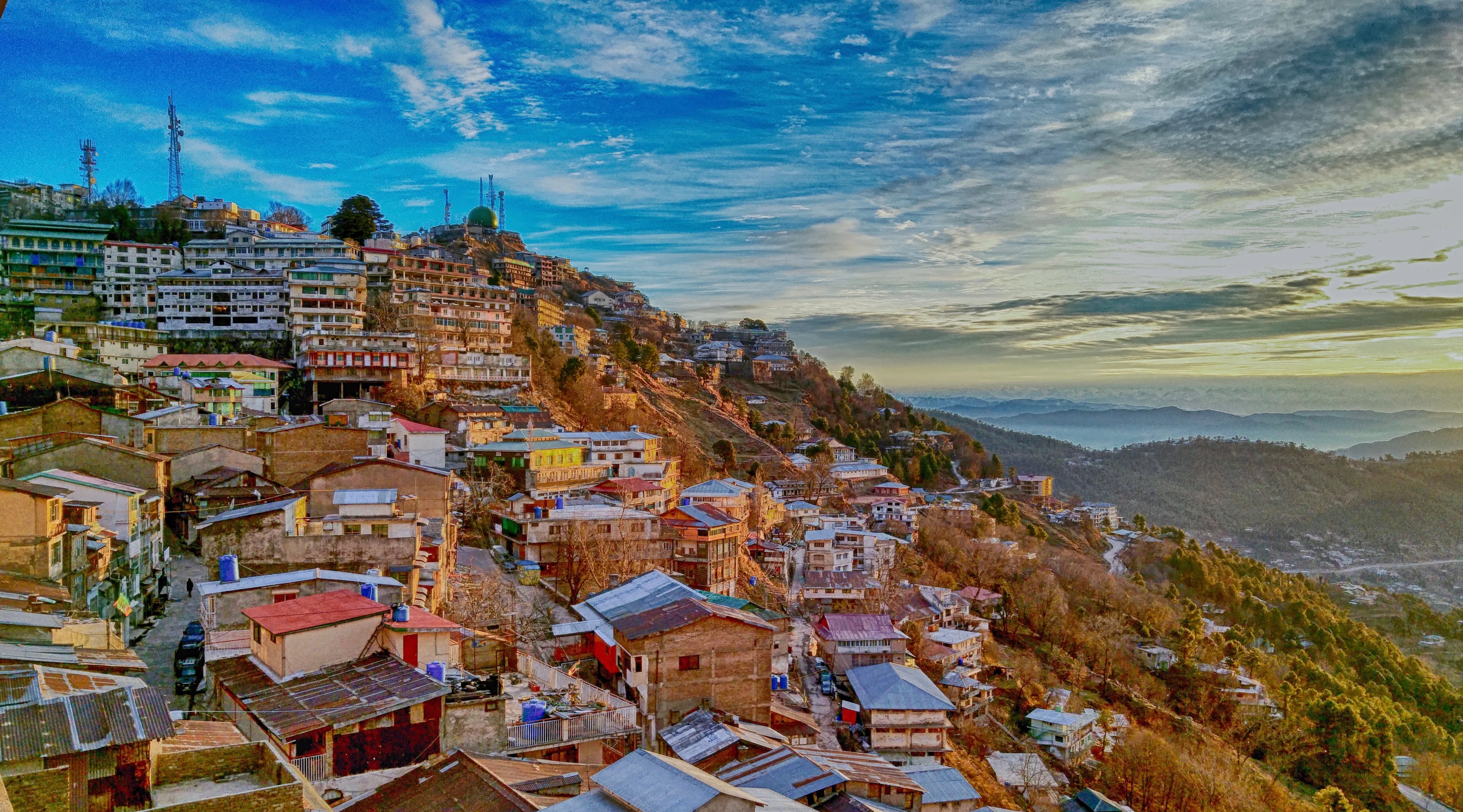 This breathtaking image showcases the serene beauty of Murree, Pakistan's beloved hill station. Nestled amidst lush greenery, the town is embraced by rolling hills and misty clouds.