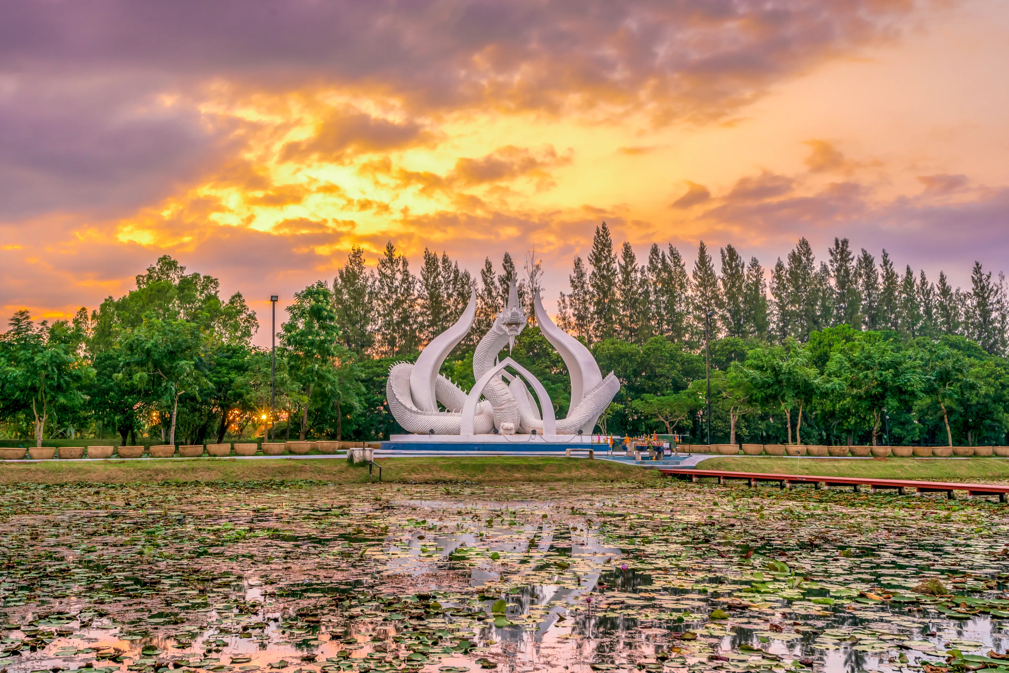 Sakon Nakhon, Thailand â€“ November 8, 2020 : The Statue of White King Naka in Lotus garden during sunset time.It is the new landmark of Sakon Nakhon, Thailand.