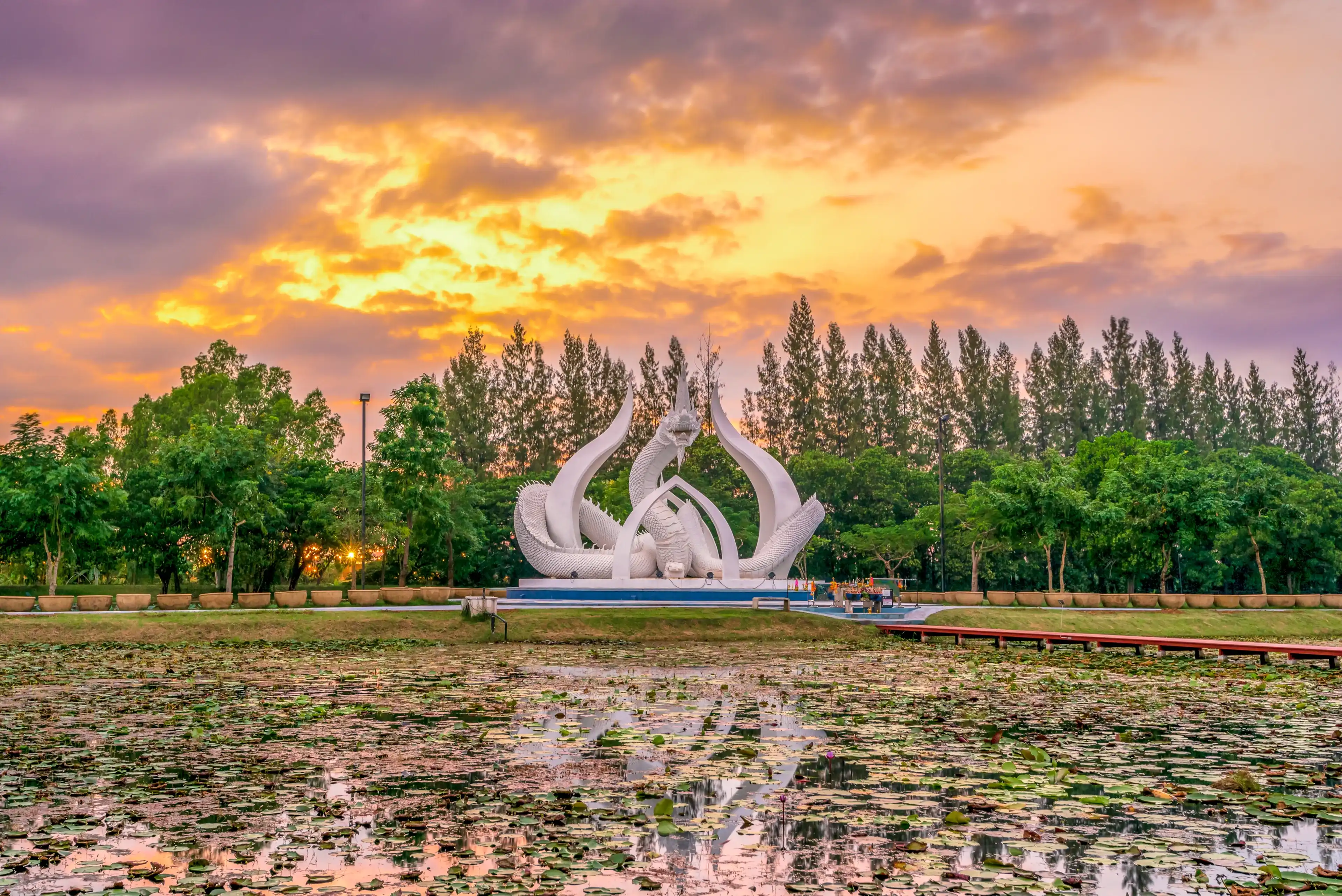Sakon Nakhon, Thailand – November 8, 2020 : The Statue of White King Naka in Lotus garden during sunset time.It is the new landmark of Sakon Nakhon, Thailand. Sakon Nakhon, Thailand – November 8, 2020 : The Statue of White King Naka in Lotus garden during sunset time.It is the new landmark of Sakon Nakhon, Thailand.
