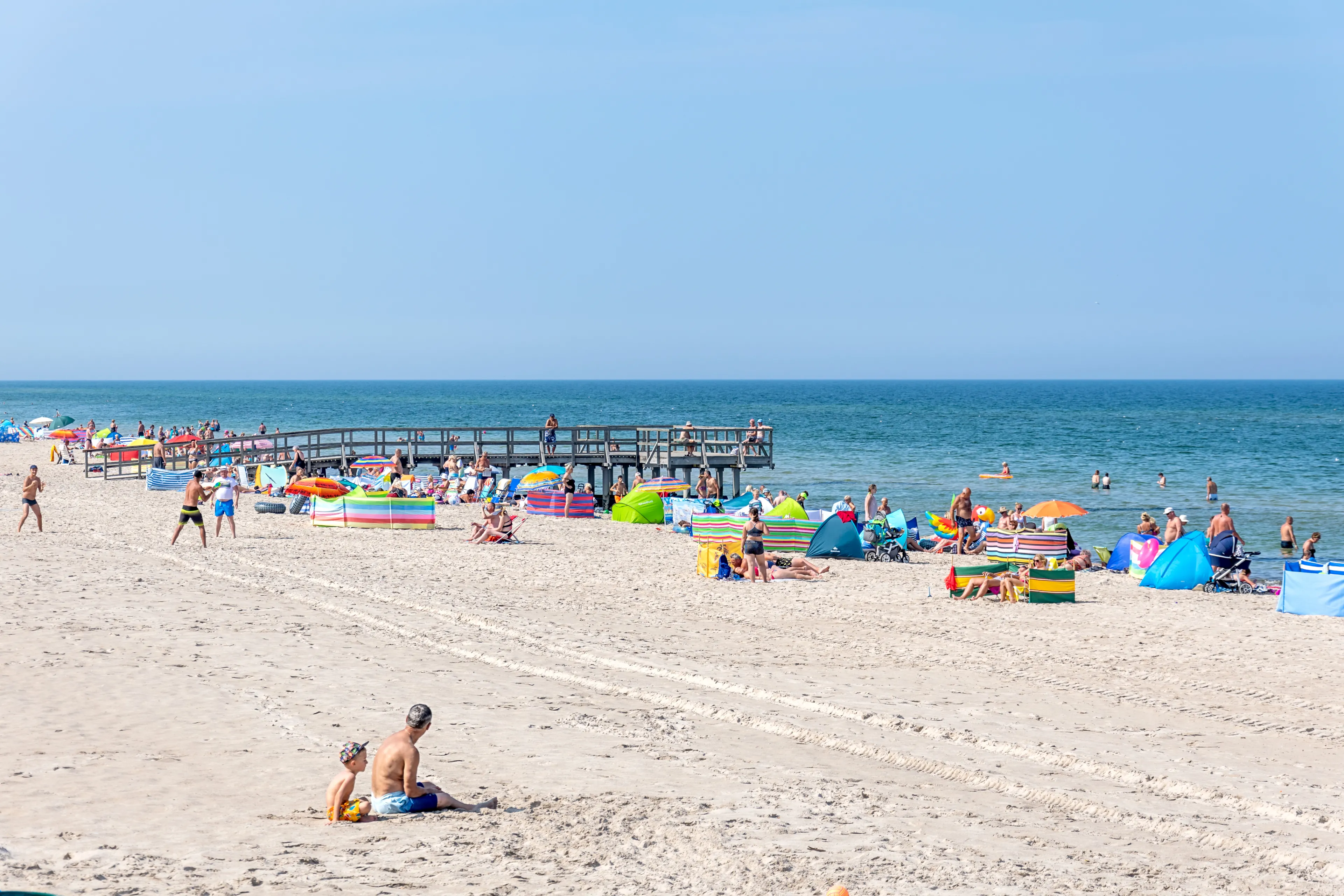 Mielno, Poland - September 29 2019: Baltic beach. Vacation by the sea. Few people are sunbathing on the sand. Holidays and fun on the water.