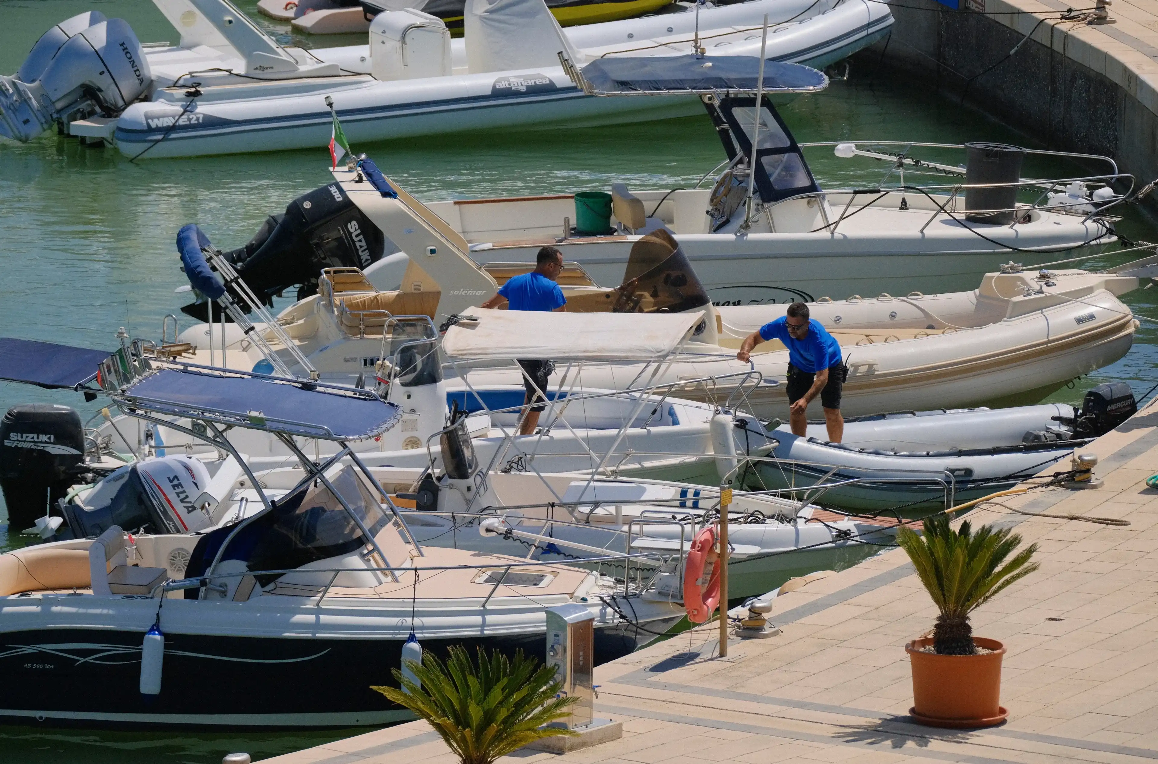 Italy, Sicily, Mediterranean sea, Marina di Ragusa (Ragusa Province); 25 July 2024, people and motor boats in the port - EDITORIAL Italy, Sicily, Mediterranean sea, Marina di Ragusa (Ragusa Province); 25 July 2024, people and motor boats in the port - EDITORIAL