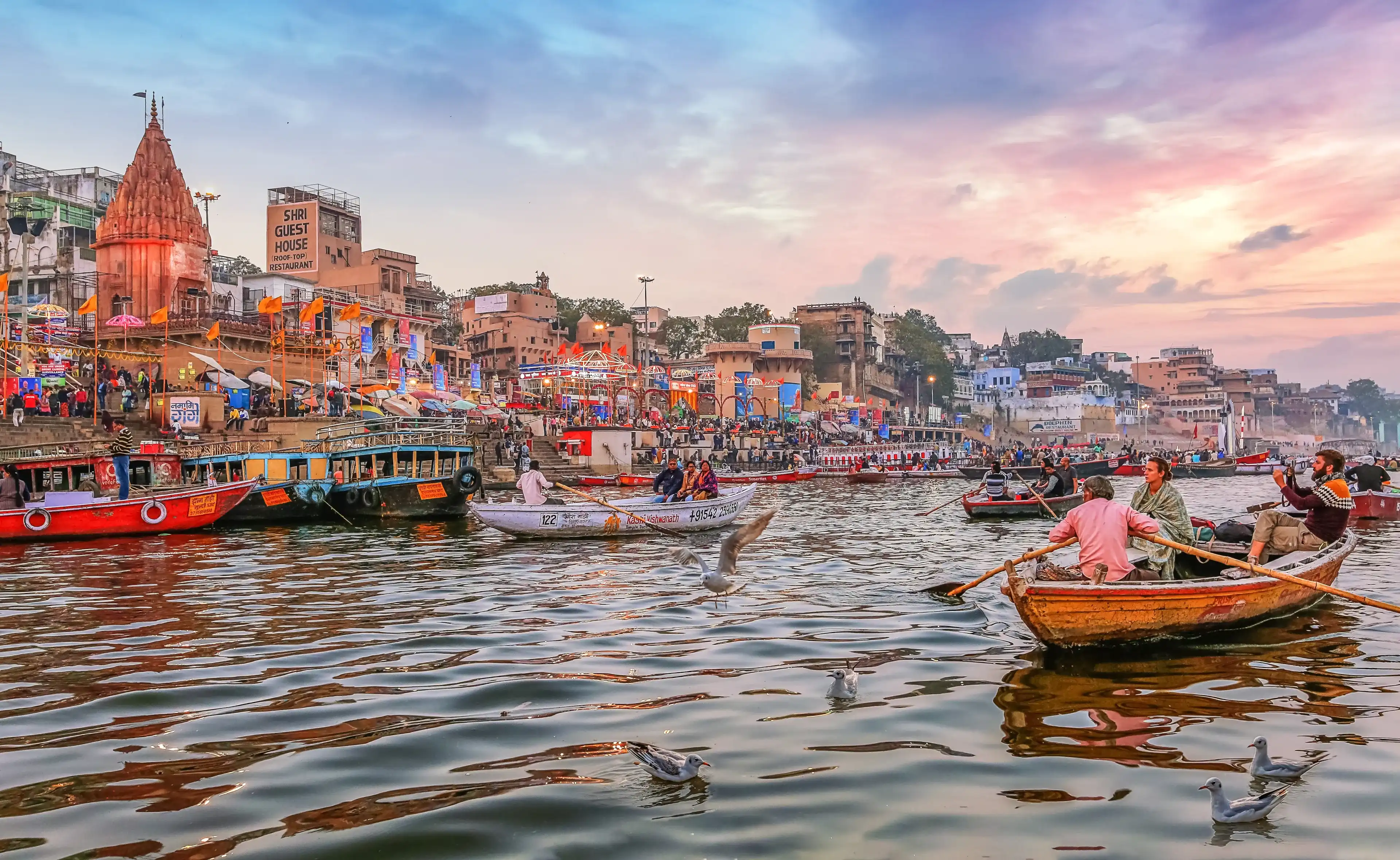 Varanasi, India, January 23,2019: Dashaswamedh Ganges river ghat Varanasi at twilight with tourists enjoying boating rides Varanasi, India, January 23,2019: Dashaswamedh Ganges river ghat Varanasi at twilight with tourists enjoying boating rides