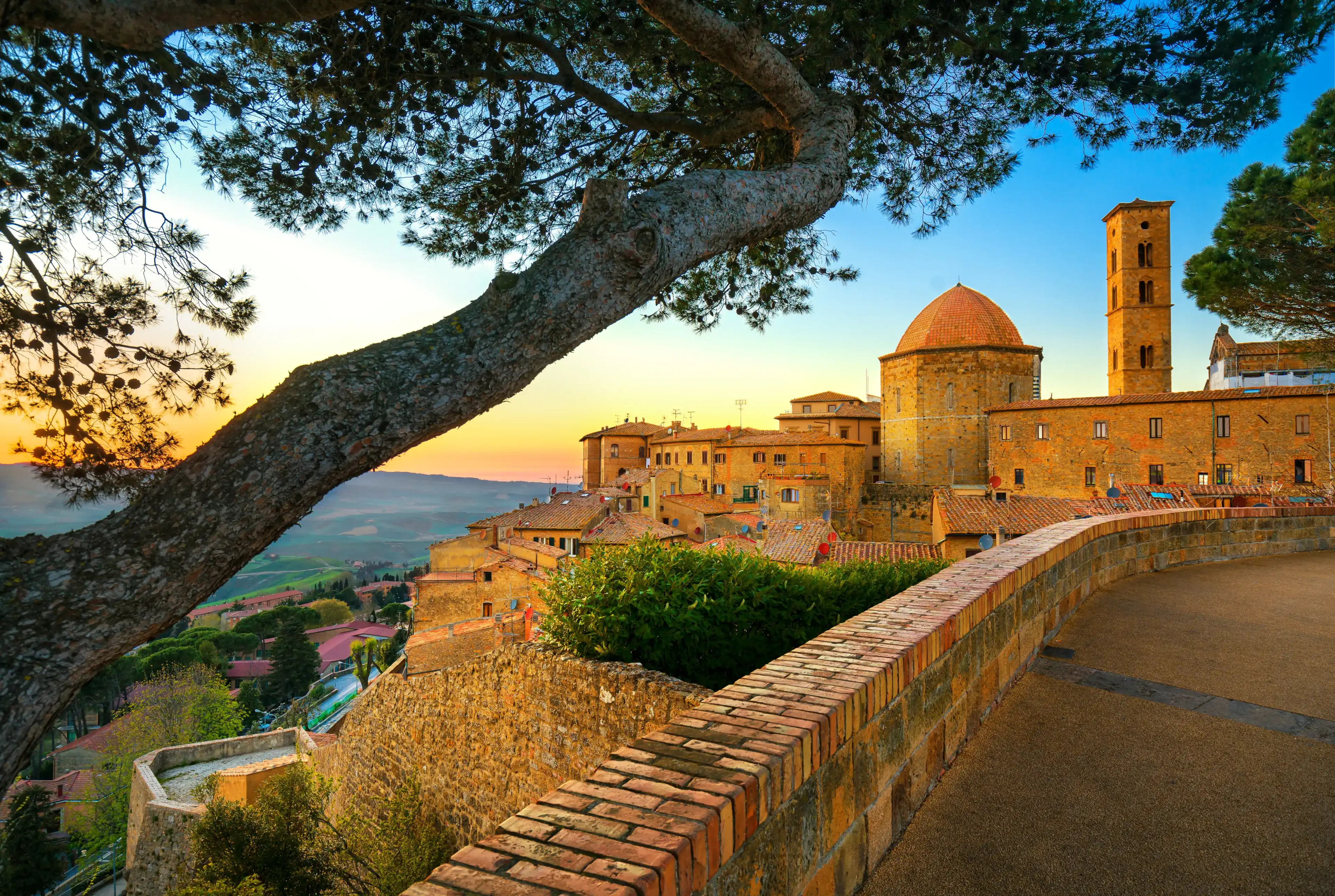 Tuscany, Volterra town skyline, church and trees on sunset. Maremma, Italy, Europe Tuscany, Volterra town skyline, church and trees on sunset. Maremma, Italy, Europe