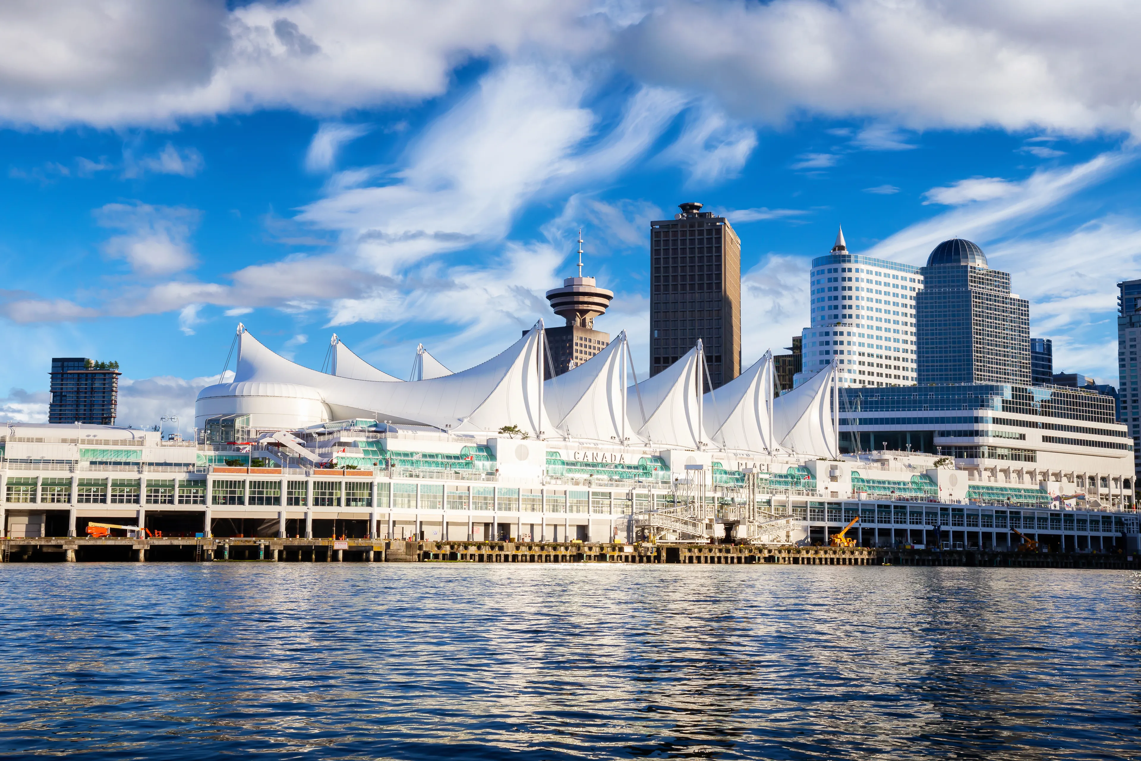 Canada Place and commercial buildings in Downtown Vancouver Viewed from water during Blue Sky Sunny Day. British Columbia, Canada. Urban Modern City Landmark