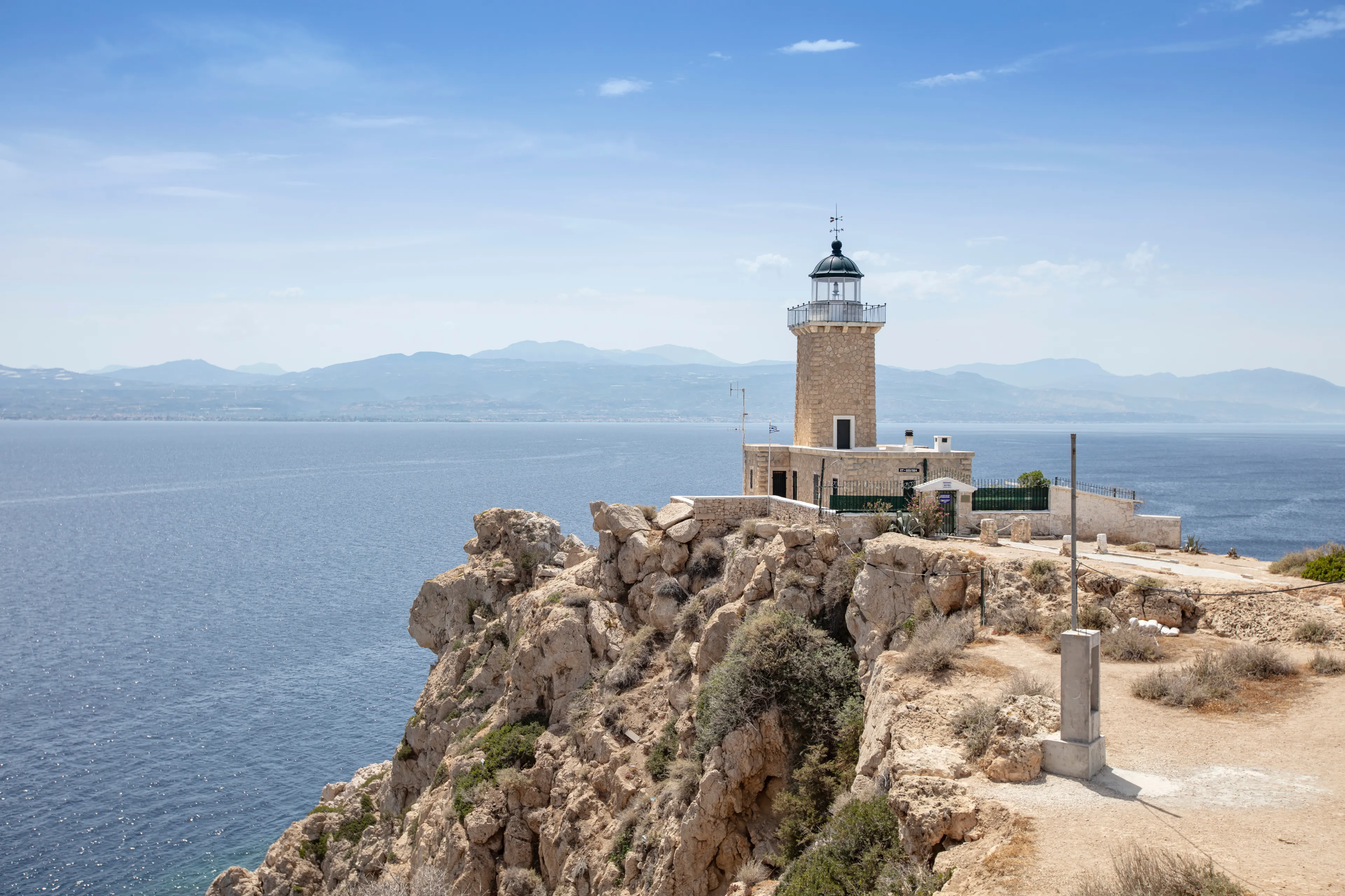 Aerial drone photo of beautiful and picturesque cape Melagavi forming a small peninsula with unique lighthouse stand out next to archaeological site of Heraion, Loutraki, Greece