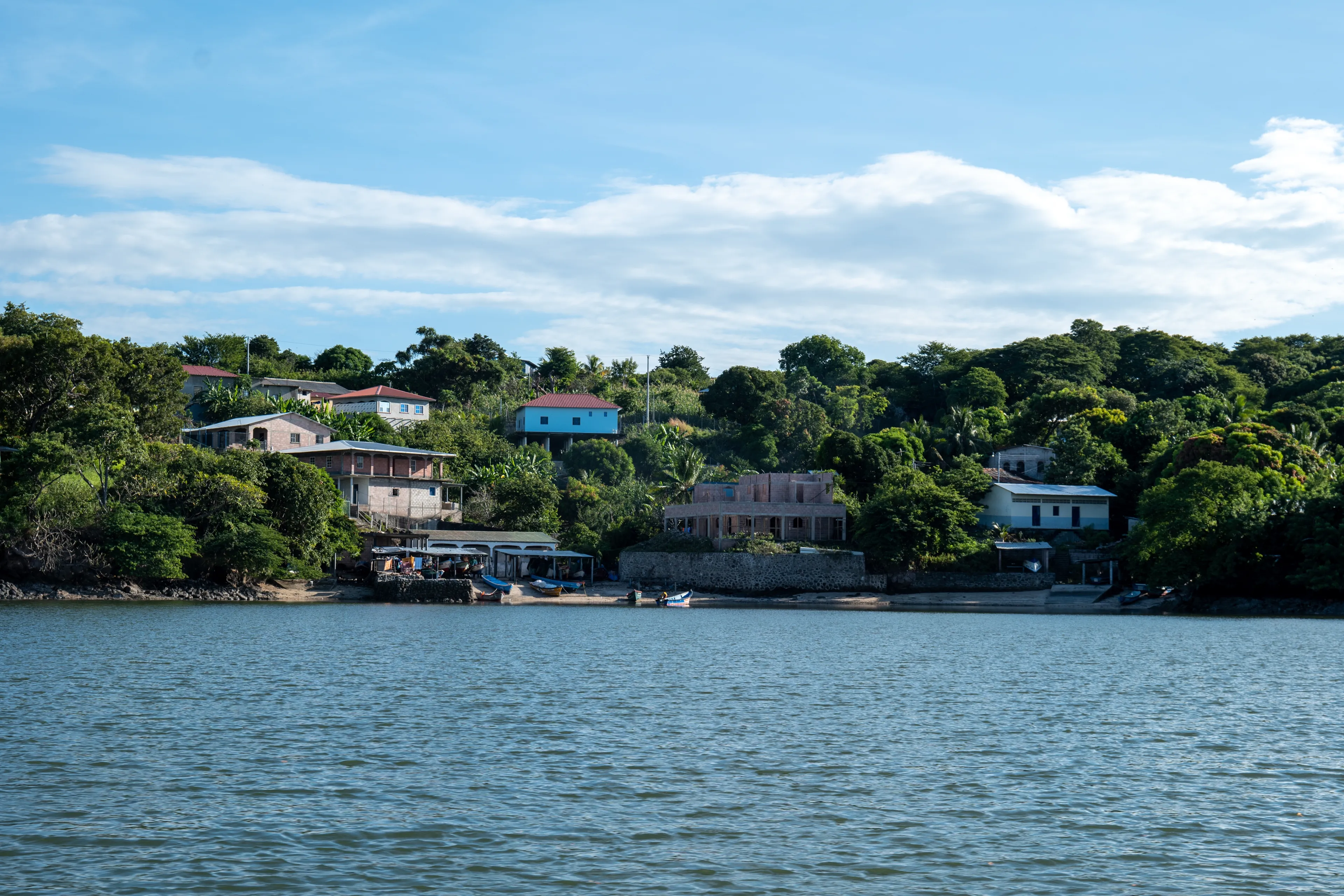 La Union, La Union, El Salvador – November 30, 2022: Paradisiacal Coastline Seen From Afar with Lush Vegetation Forest, and Colorful Houses by a Calm Ocean