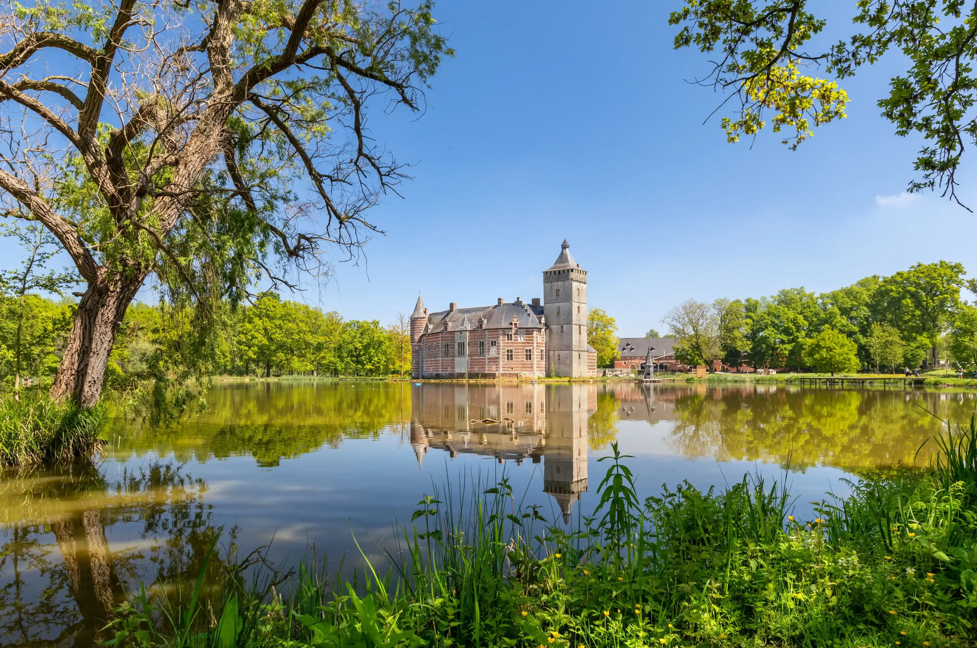 Holsbeek, Belgium - May 06 2022: View of historic Castle Van Horst with lake and park in summer day Holsbeek, Belgium - May 06 2022: View of historic Castle Van Horst with lake and park in summer day