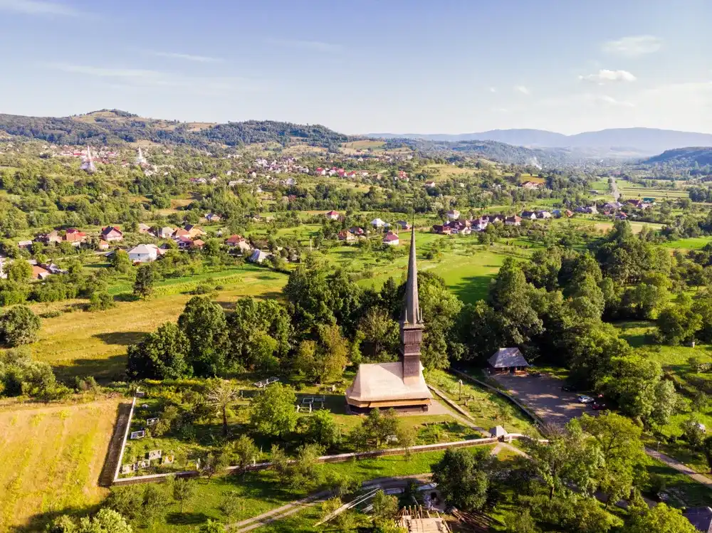 Beautiful aerial view on the Church of the Archangels Michael and Gabriel in Surdesti, Maramures County near Baia Mare, Romania. Traditional Maramures wooden architecture. UNESCO world heritage site. Beautiful aerial view on the Church of the Archangels Michael and Gabriel in Surdesti, Maramures County near Baia Mare, Romania. Traditional Maramures wooden architecture. UNESCO world heritage site.