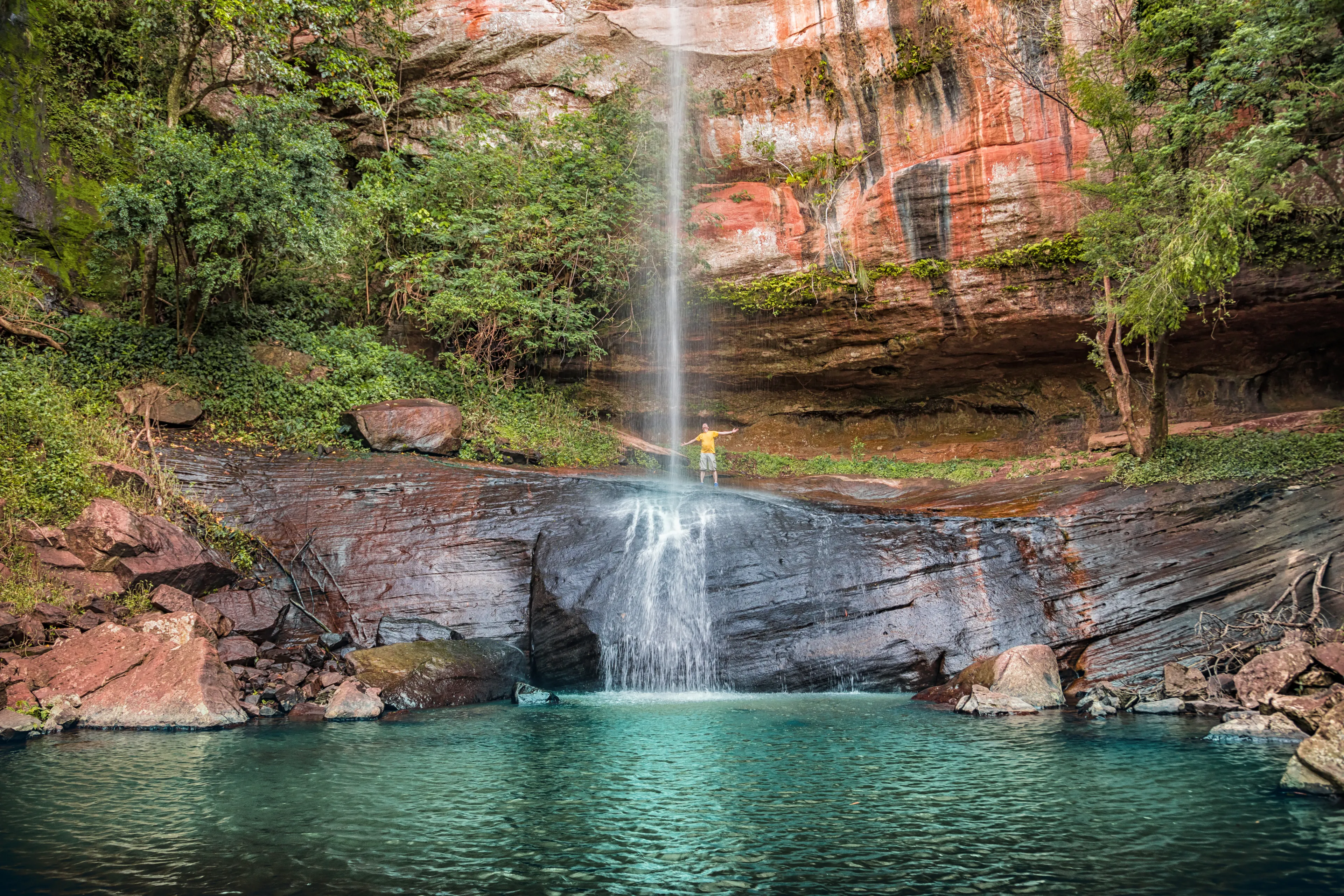 A man behind the "Salto Suizo" the highest waterfall of Paraguay near the Colonia Independencia and Vallarrica.