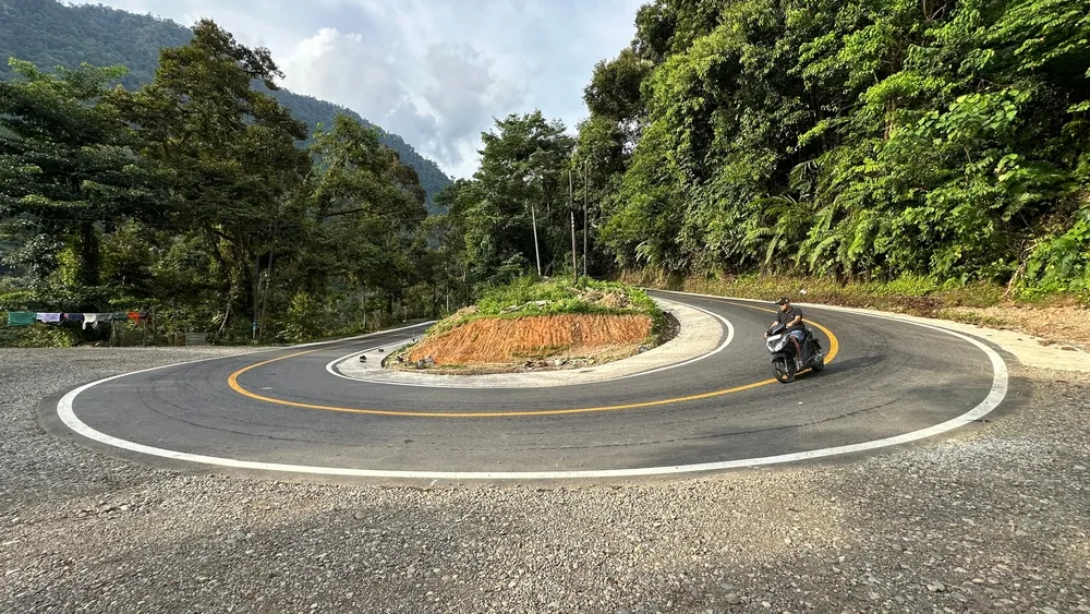 Bengkulu, Indonesia, December 14, 2024 : Motorcyclist passing a sharp bend in the hill, 4k, landscape, portrait