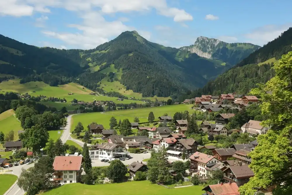 view of Château-d'Œx in Switzerland. Swiss village from above. Château-d'Œx from above surrounded by mountains. Château-d'Oex July 2024 view of Château-d'Œx in Switzerland. Swiss village from above. Château-d'Œx from above surrounded by mountains. Château-d'Oex July 2024