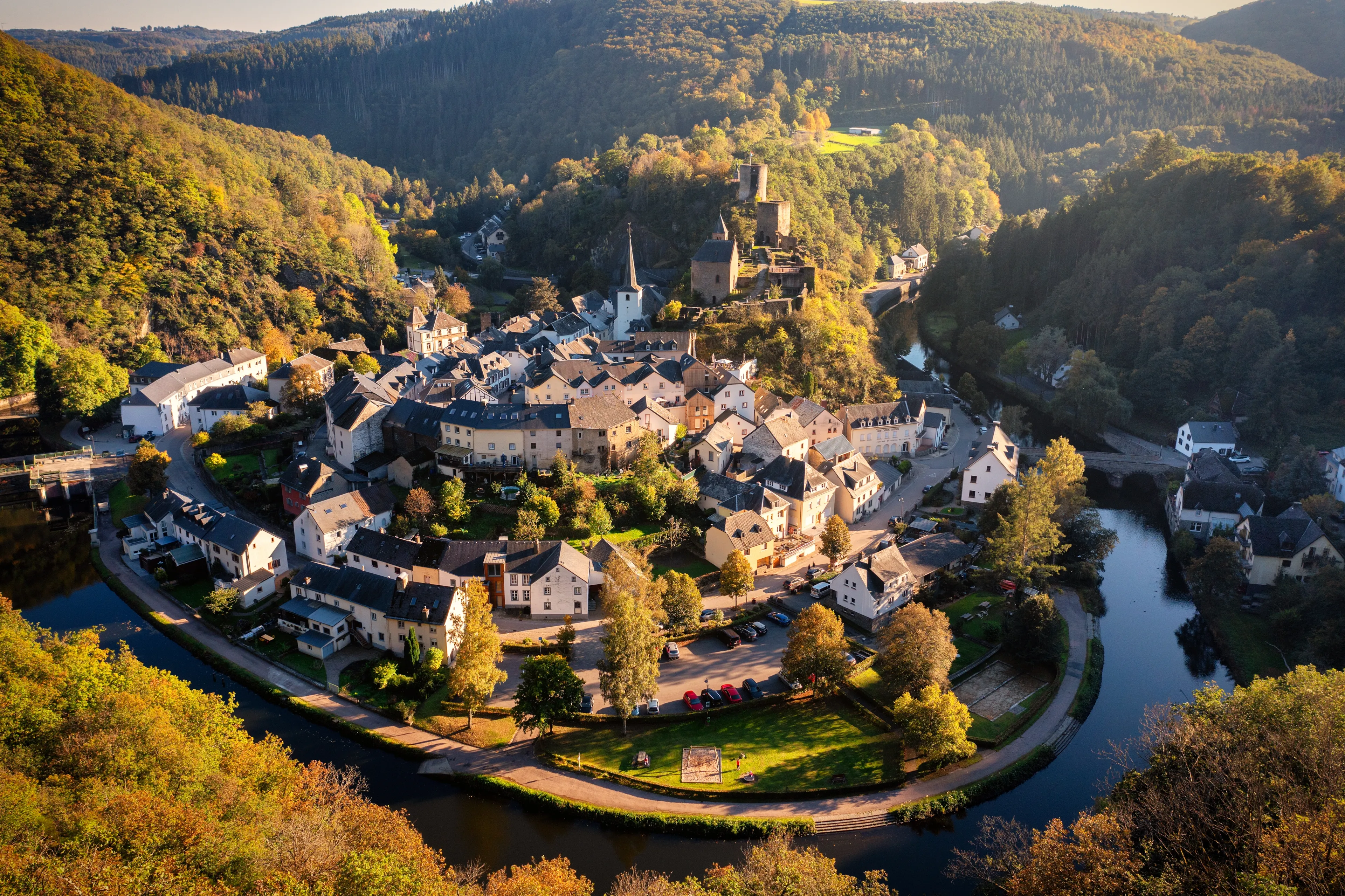 Aerial view of Esch-sur-Sure, medieval town in Luxembourg, dominated by castle, canton Wiltz in Diekirch. Forests of Upper-Sure Nature Park, meander of winding river Sauer, near Upper Sauer Lake.