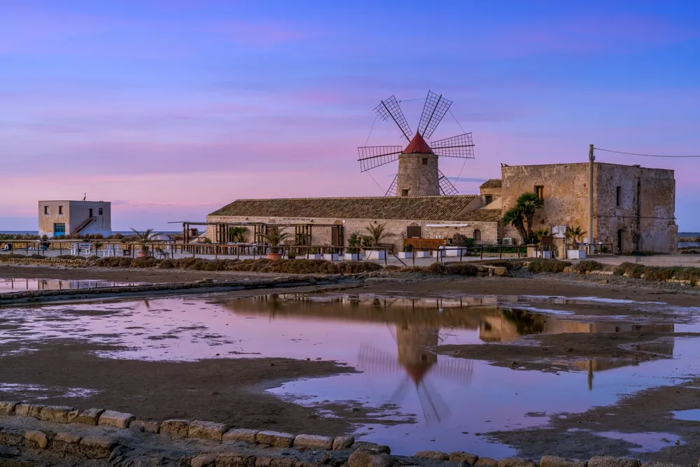 Paceco, Italy - 3 January, 2024: view of the windmill and salt flat museum of Paceco at sunset
