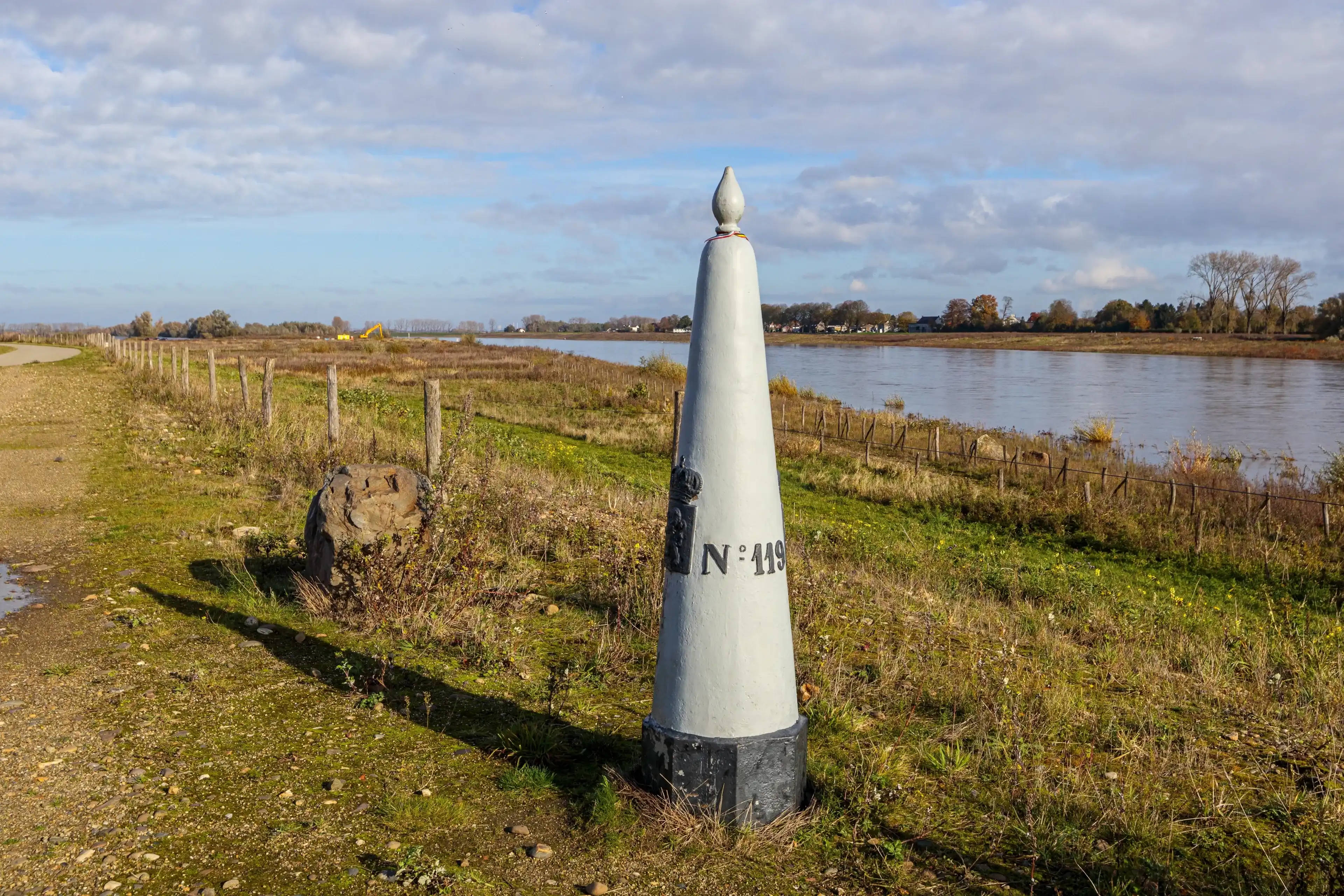 Belgian nature reserve De Wissen Maasvallei with a border marker between Belgium and Holland, Maas river in misty background, sunny autumn day in Dilsen-Stokkem, Belgium. Treaty of Maastricht of 1843 Belgian nature reserve De Wissen Maasvallei with a border marker between Belgium and Holland, Maas river in misty background, sunny autumn day in Dilsen-Stokkem, Belgium. Treaty of Maastricht of 1843