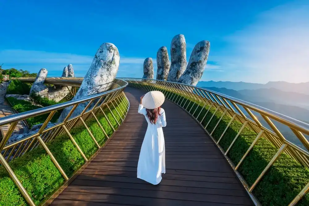 Vietnamese girl with traditional dress (ao dai) on Golden bridge at the top of the Ba Na Hills, Vietnam Vietnamese girl with traditional dress (ao dai) on Golden bridge at the top of the Ba Na Hills, Vietnam