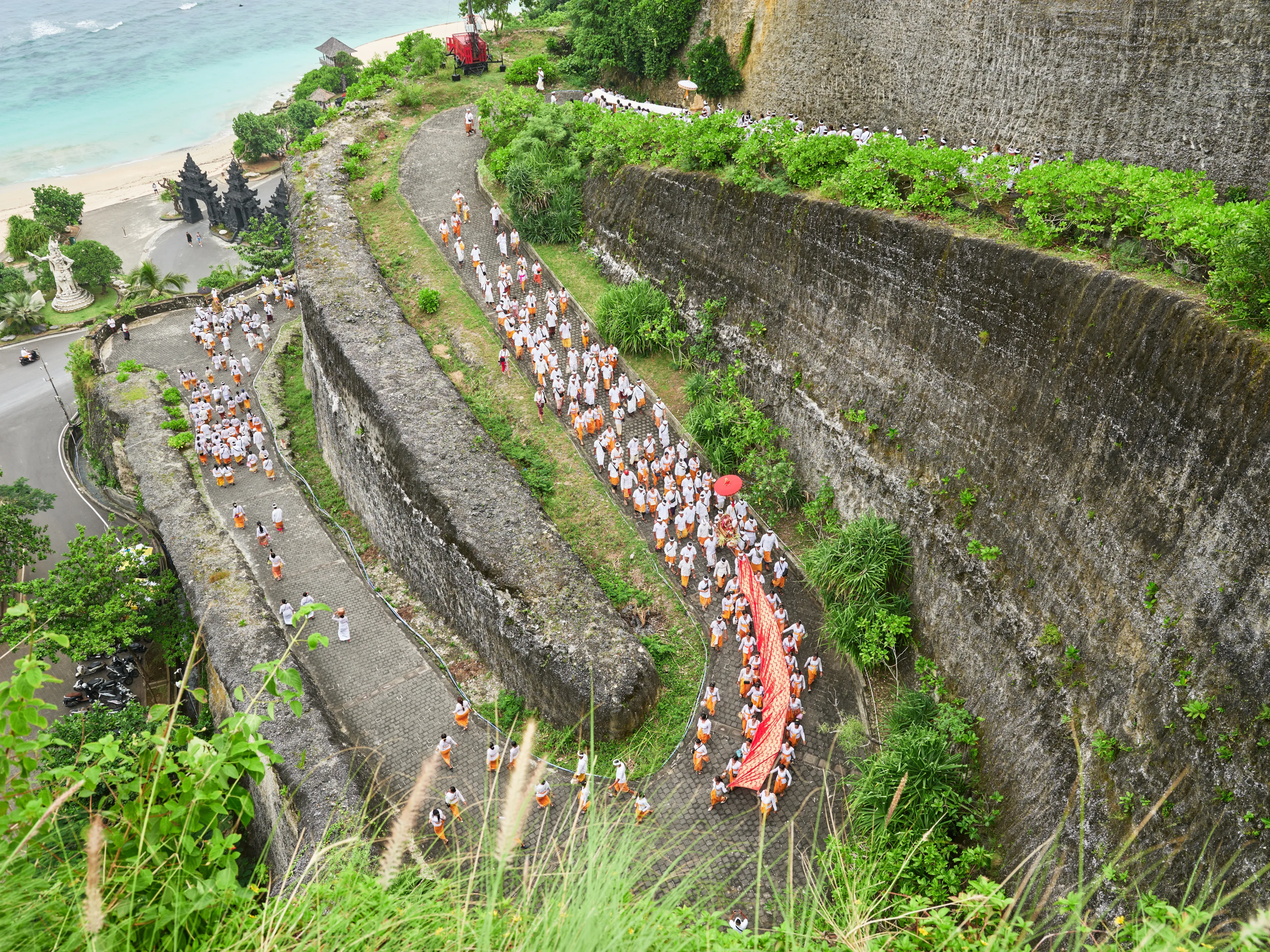 Ungasan, Bali Indonesia, March 26, 2025: Melasti ceremony - purification before Nyepi day on the winding road on the exotic steep coast of southern Bali