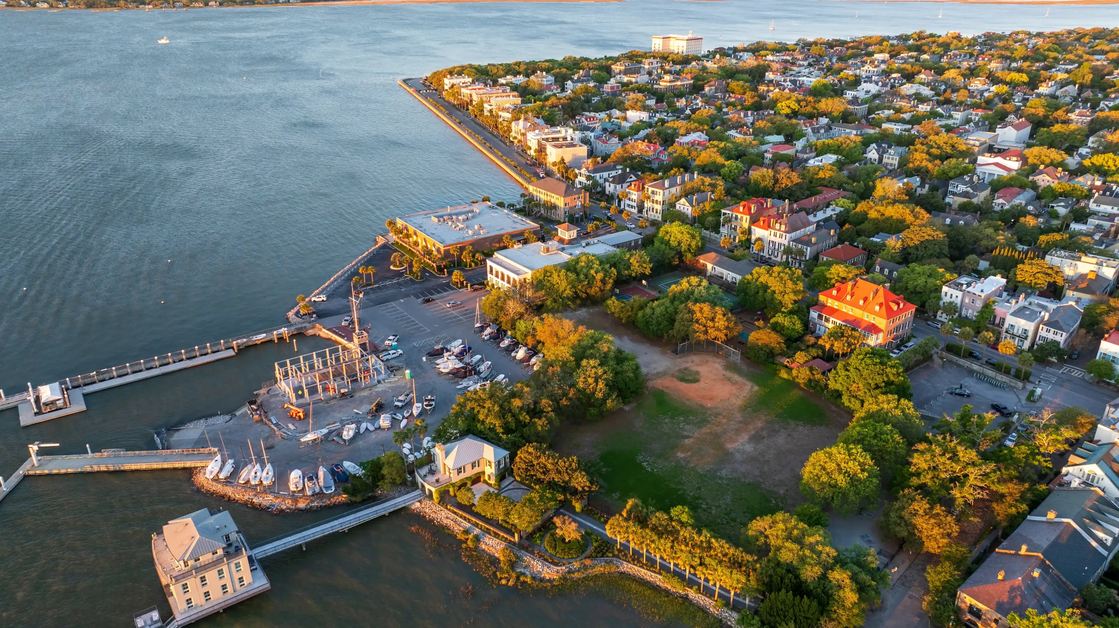 Golden sunrise light bathes downtown Charleston, South Carolina, with historic buildings and streets visible from an aerial view. Golden sunrise light bathes downtown Charleston, South Carolina, with historic buildings and streets visible from an aerial view.