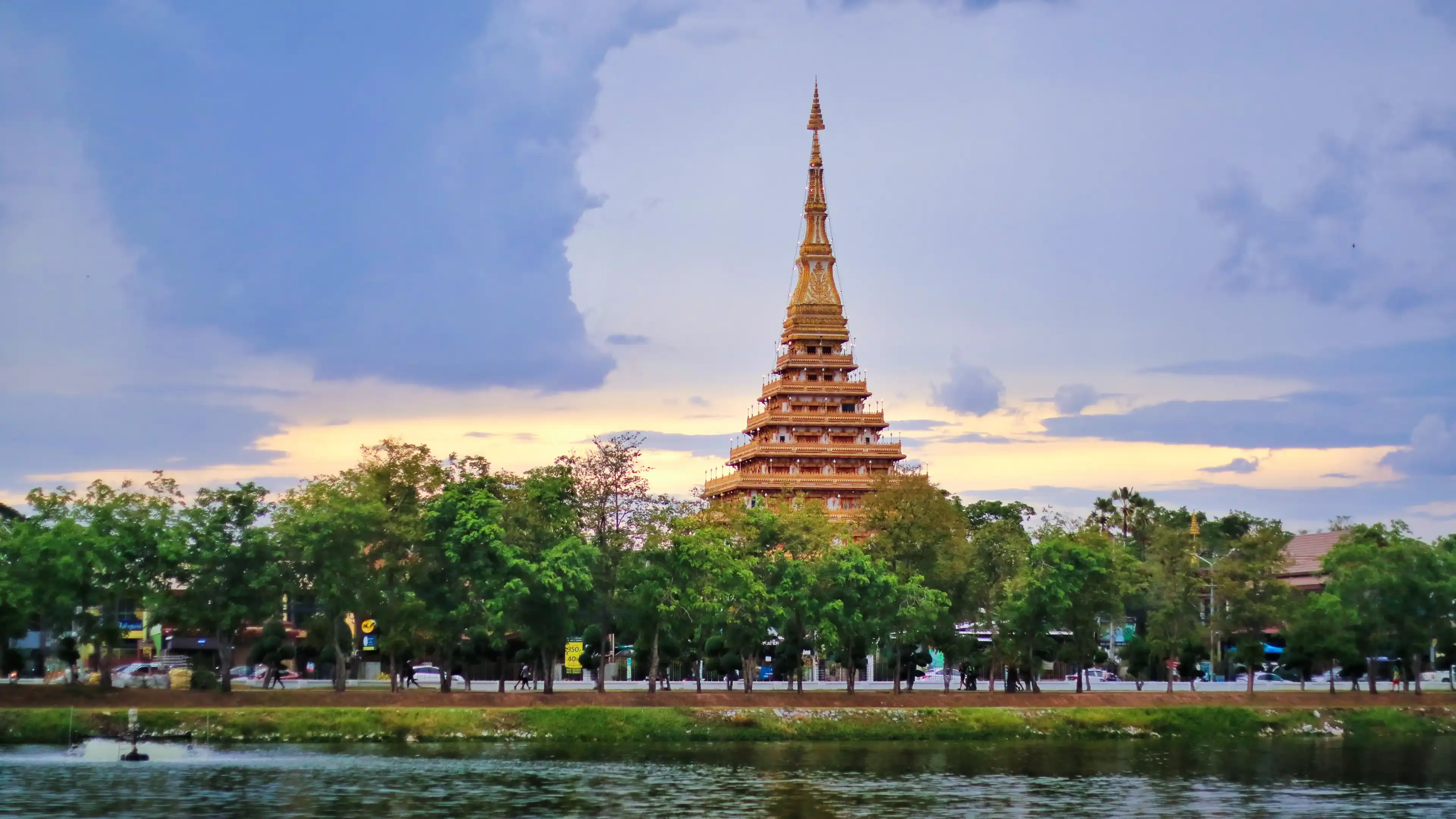 Beautiful sunset view of golden nine storey Called "Phra Mahathat Kaen Nakhon" or "Wat Nong Wang" surrounded with lake at Khon Kaen town. Beautiful sunset view of golden nine storey Called "Phra Mahathat Kaen Nakhon" or "Wat Nong Wang" surrounded with lake at Khon Kaen town.