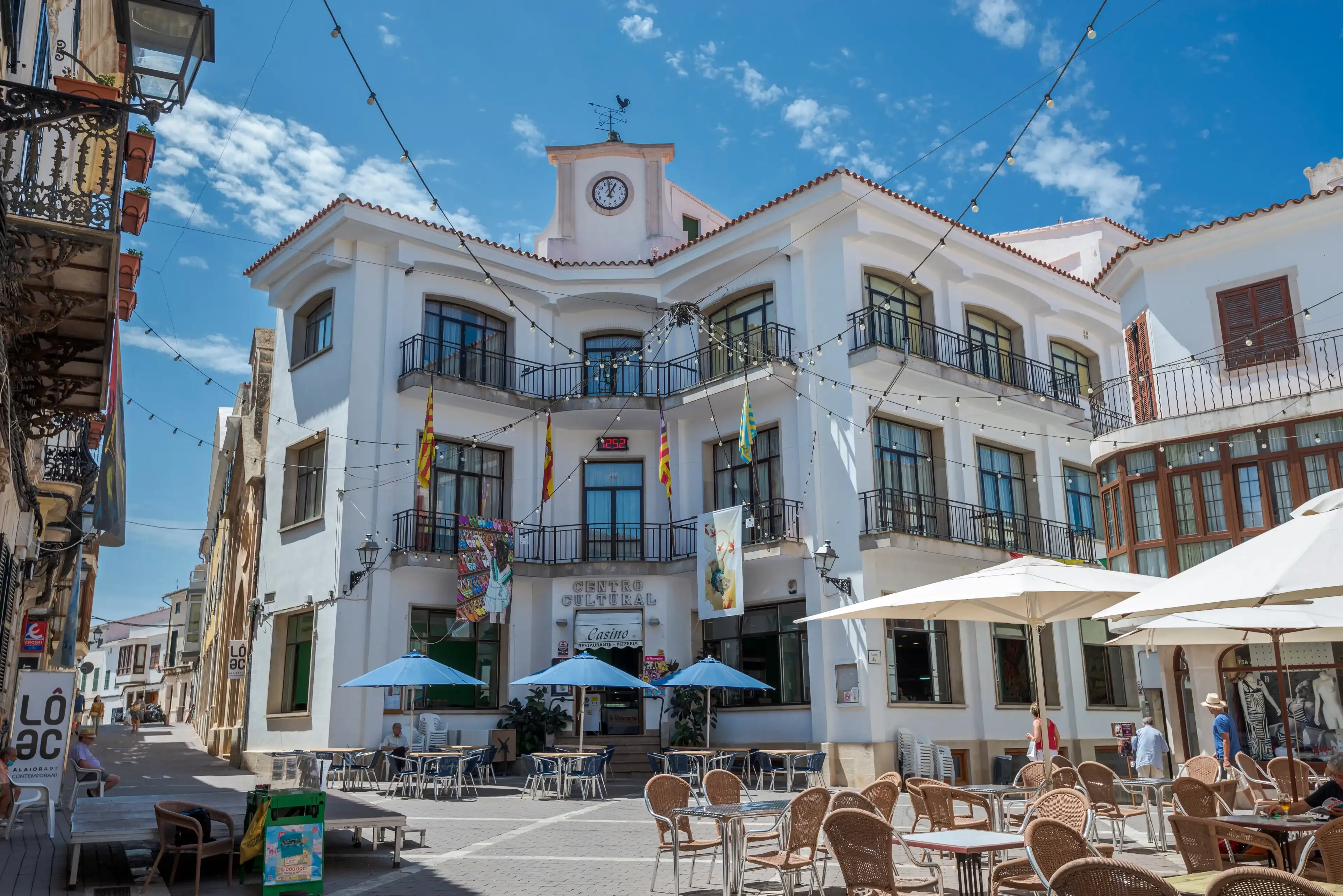 ALAIOR, SPAIN – AUGUST 3, 2021: Views of the Constitution Square in Alaior, a small city in Menorca, Balearic Islands ALAIOR, SPAIN – AUGUST 3, 2021: Views of the Constitution Square in Alaior, a small city in Menorca, Balearic Islands