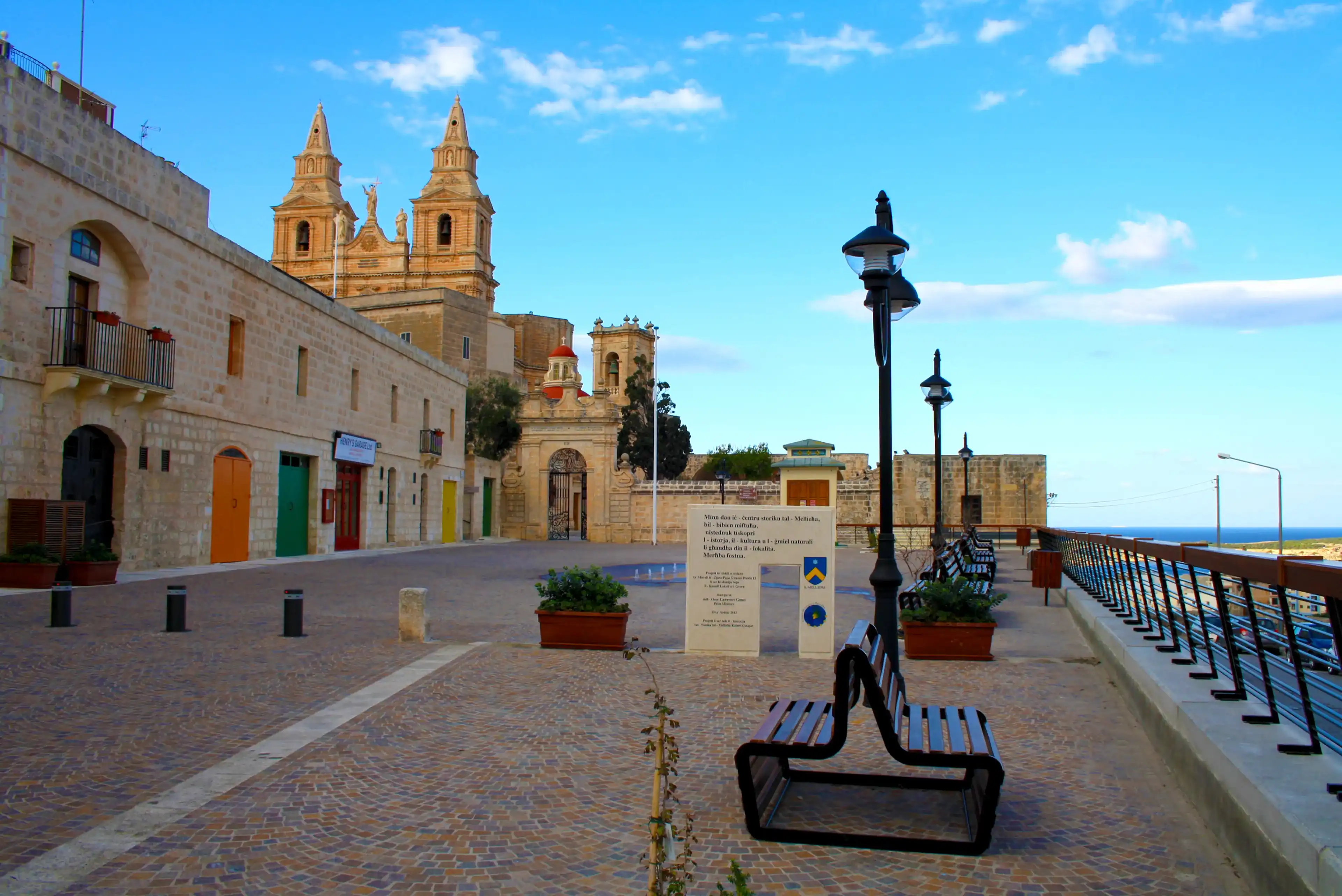 Mellieha, Malta - December 29, 2012: Wonderful outdoor patio at the bottom of the Sanctuary of Our Lady of Mellieħa with benches and a beautiful blue sky, Malta Mellieha, Malta - December 29, 2012: Wonderful outdoor patio at the bottom of the Sanctuary of Our Lady of Mellieħa with benches and a beautiful blue sky, Malta