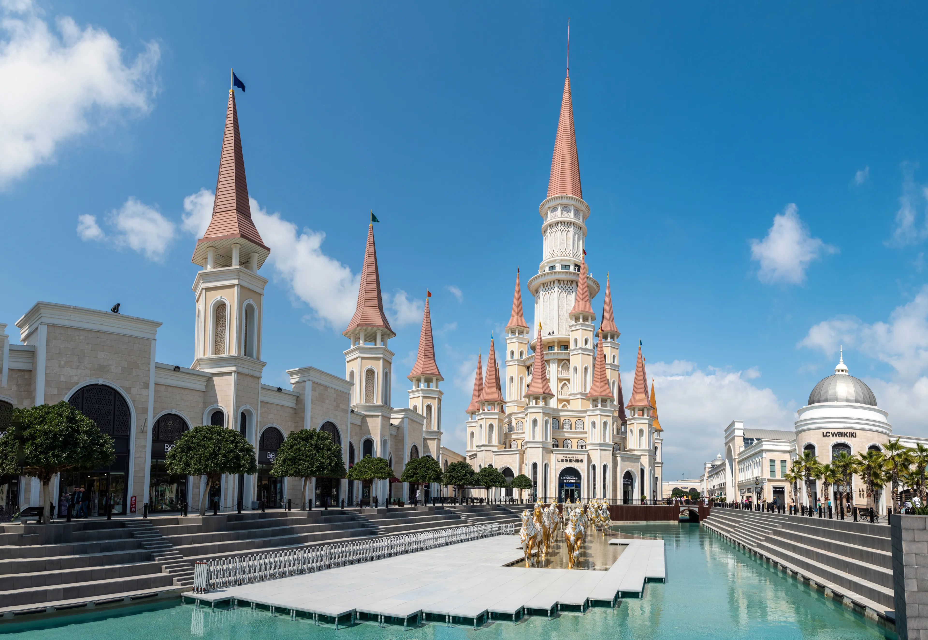 Belek, Antalya, Turkey - March 27, 2023. The Land of Legends theme park in Belek, Turkey. View toward the Chateau building, with a pool and chariot monument.