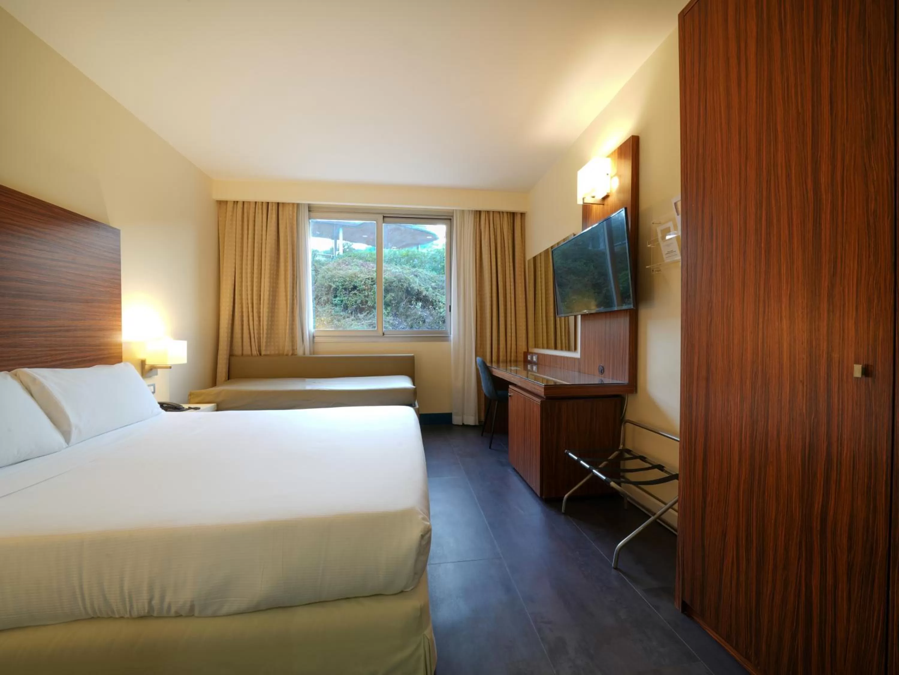 Bed in La Meridiana Bleisure Hotel