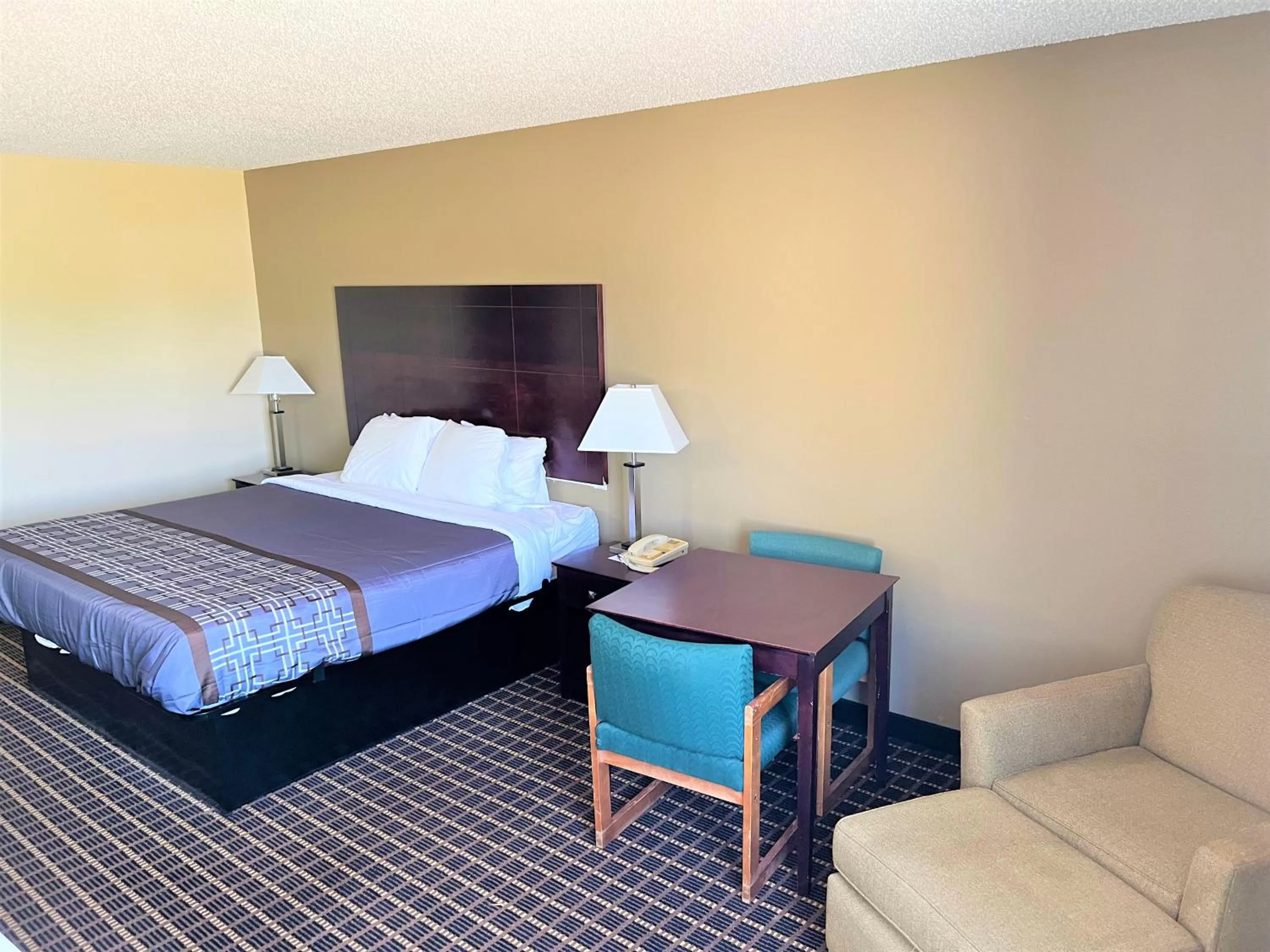 Bed in Designer Inn and Suites