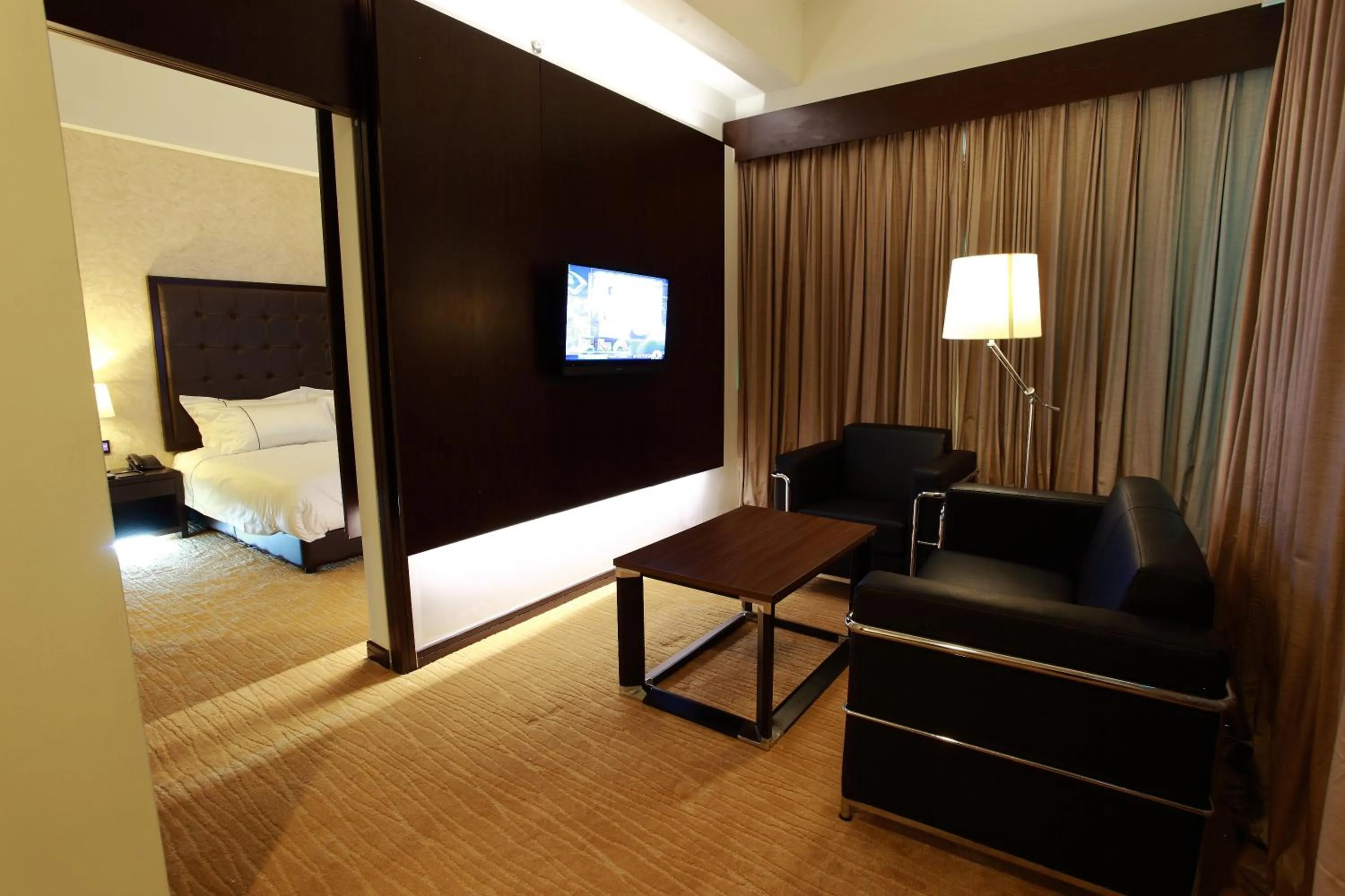 Living room, Bed in Symphony Suites Hotel
