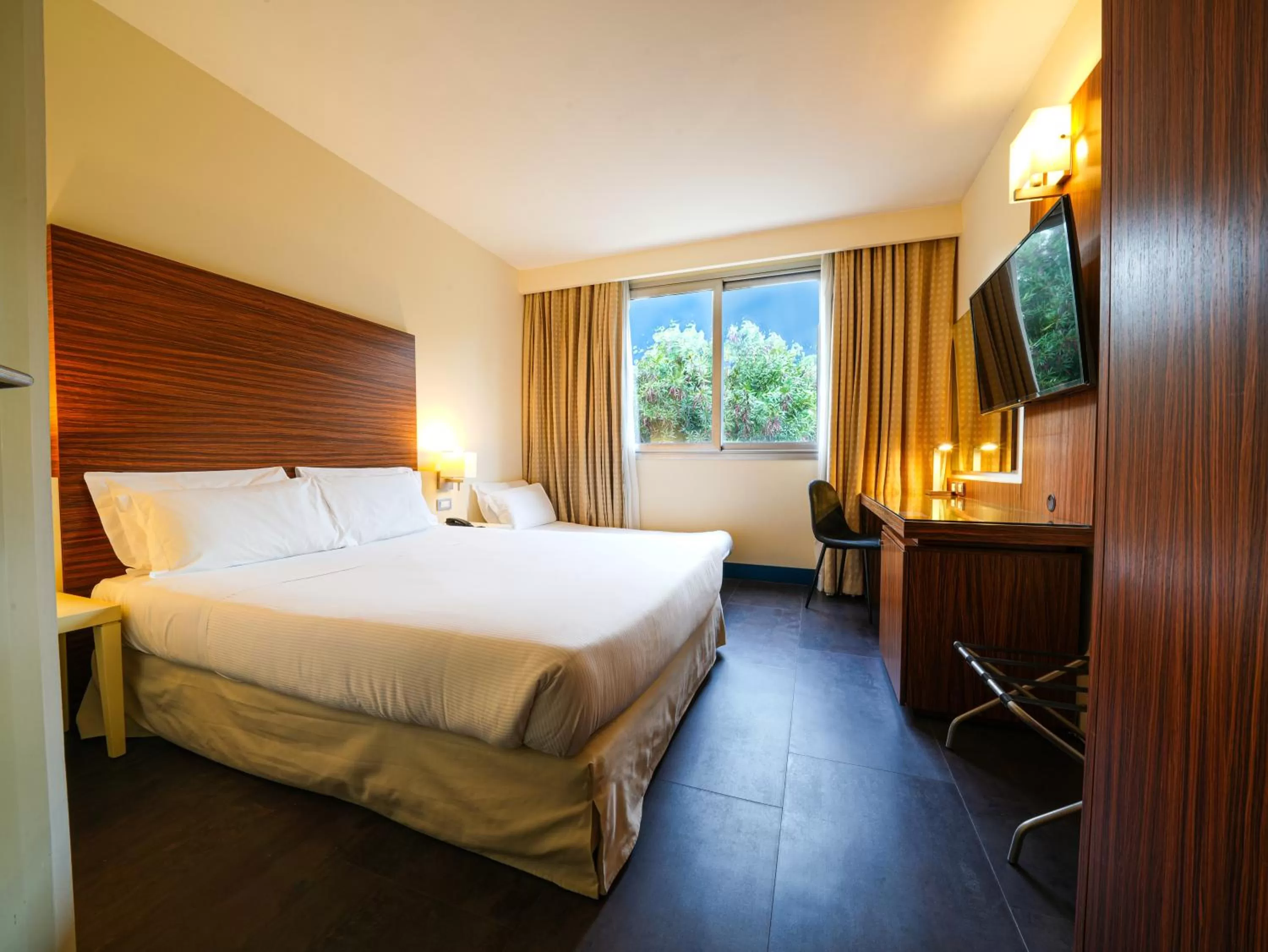 Bed in La Meridiana Bleisure Hotel