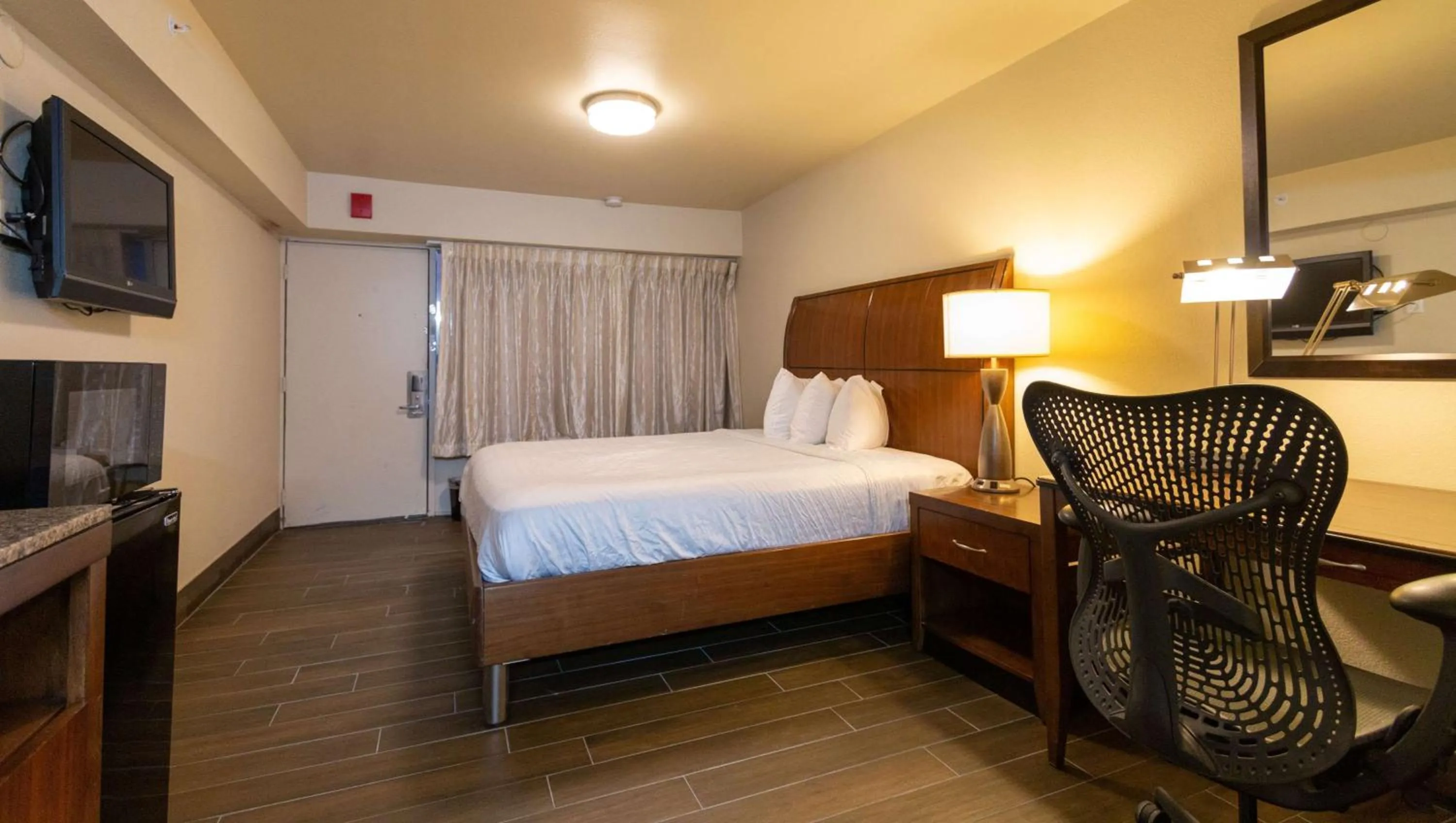 Photo of the whole room, Bed in Magnuson Extended Stay and Suites Airport Hotel
