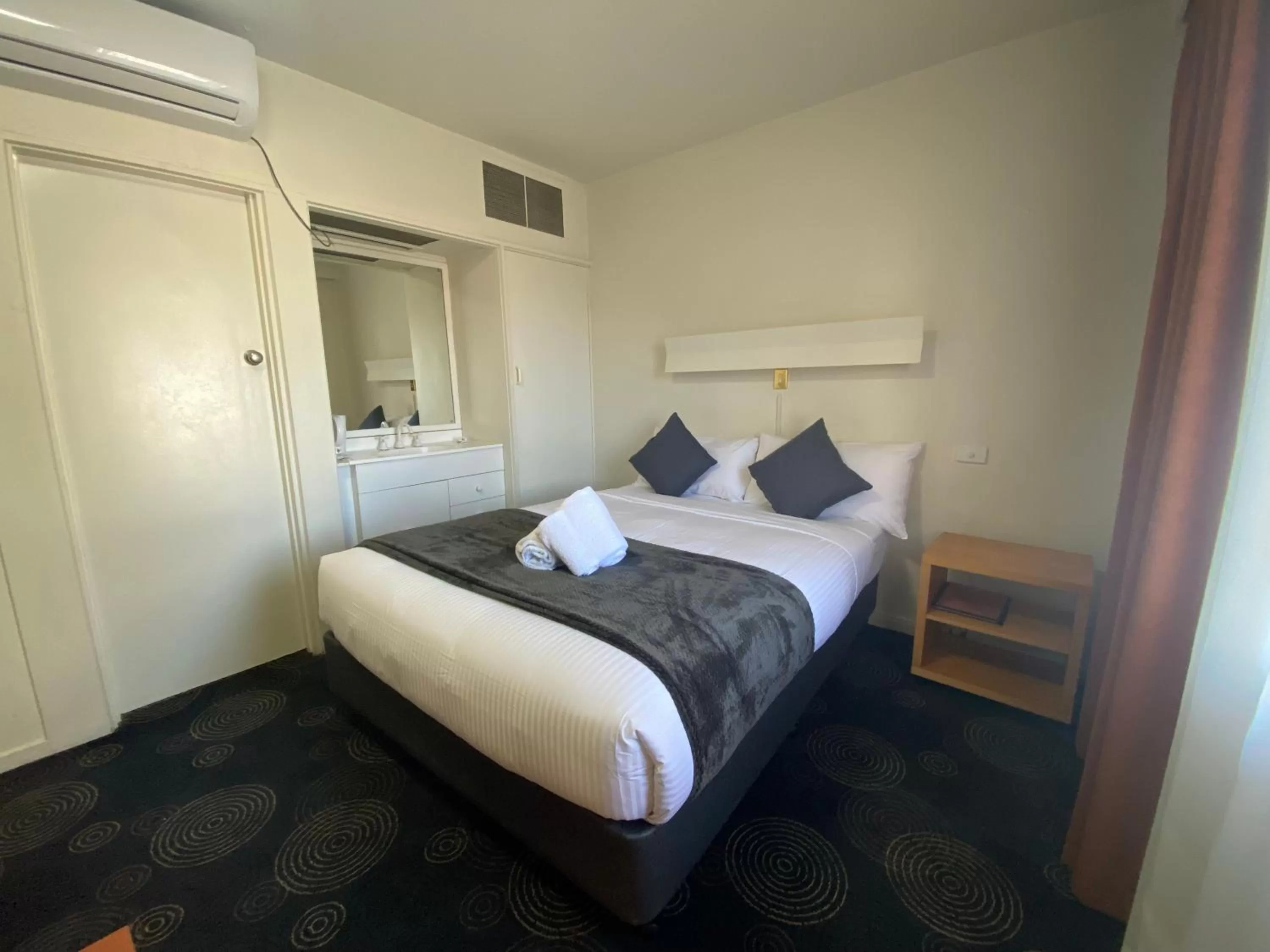 Bed in The Astor Hotel Motel