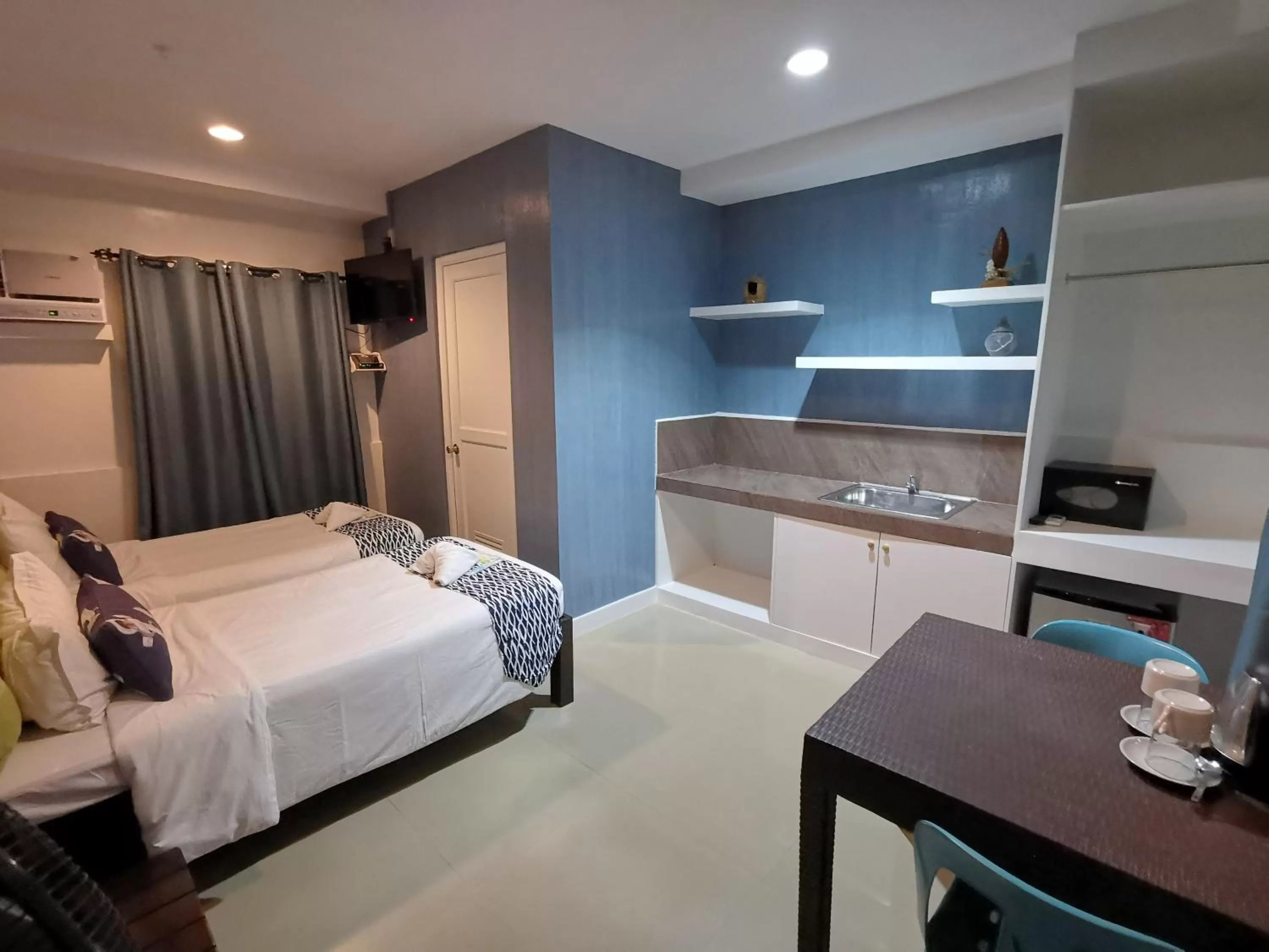 Bed, Kitchen/Kitchenette in Pescadores Suites Moalboal