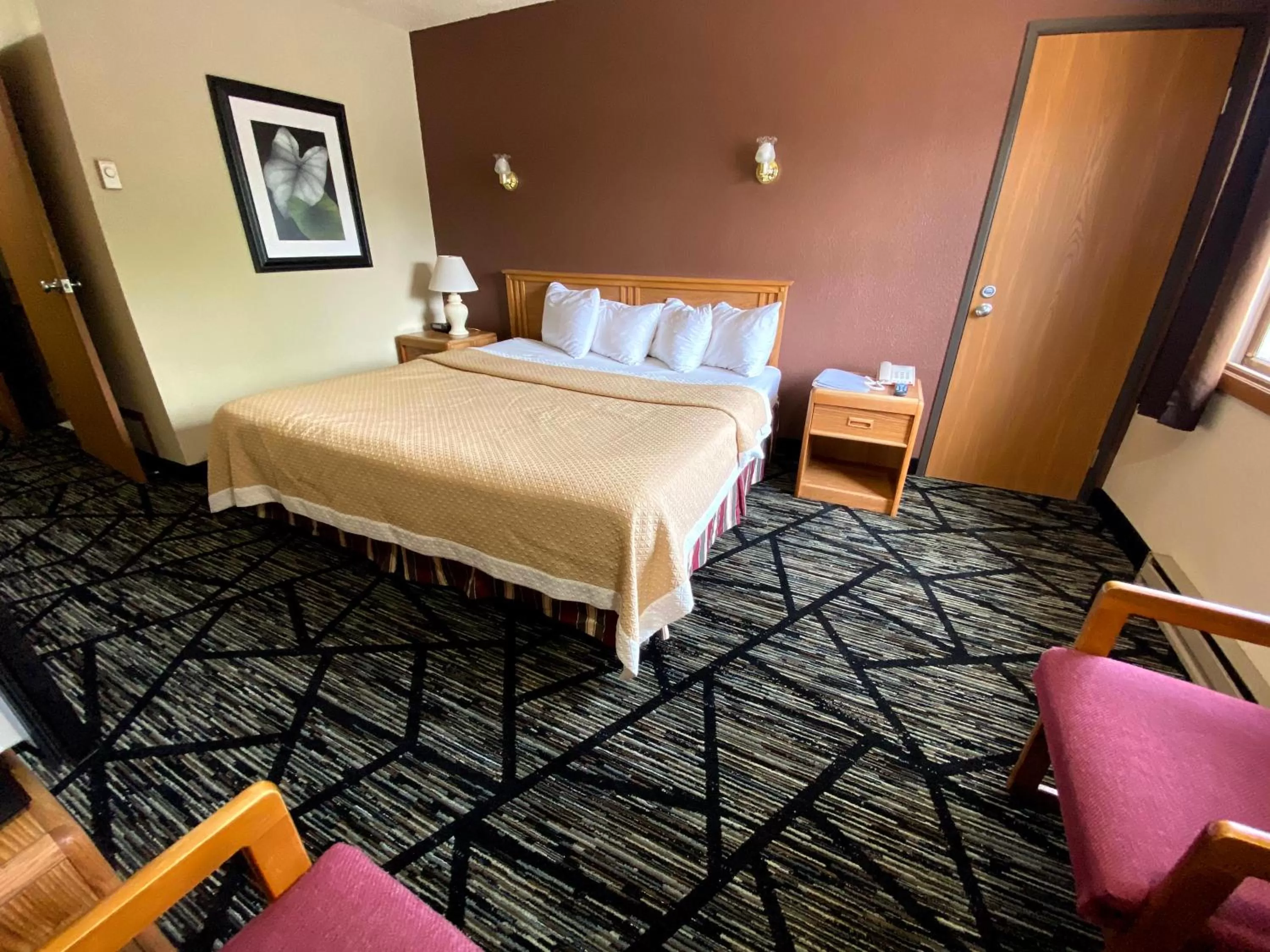 Bed in Woodland Inn & Suites