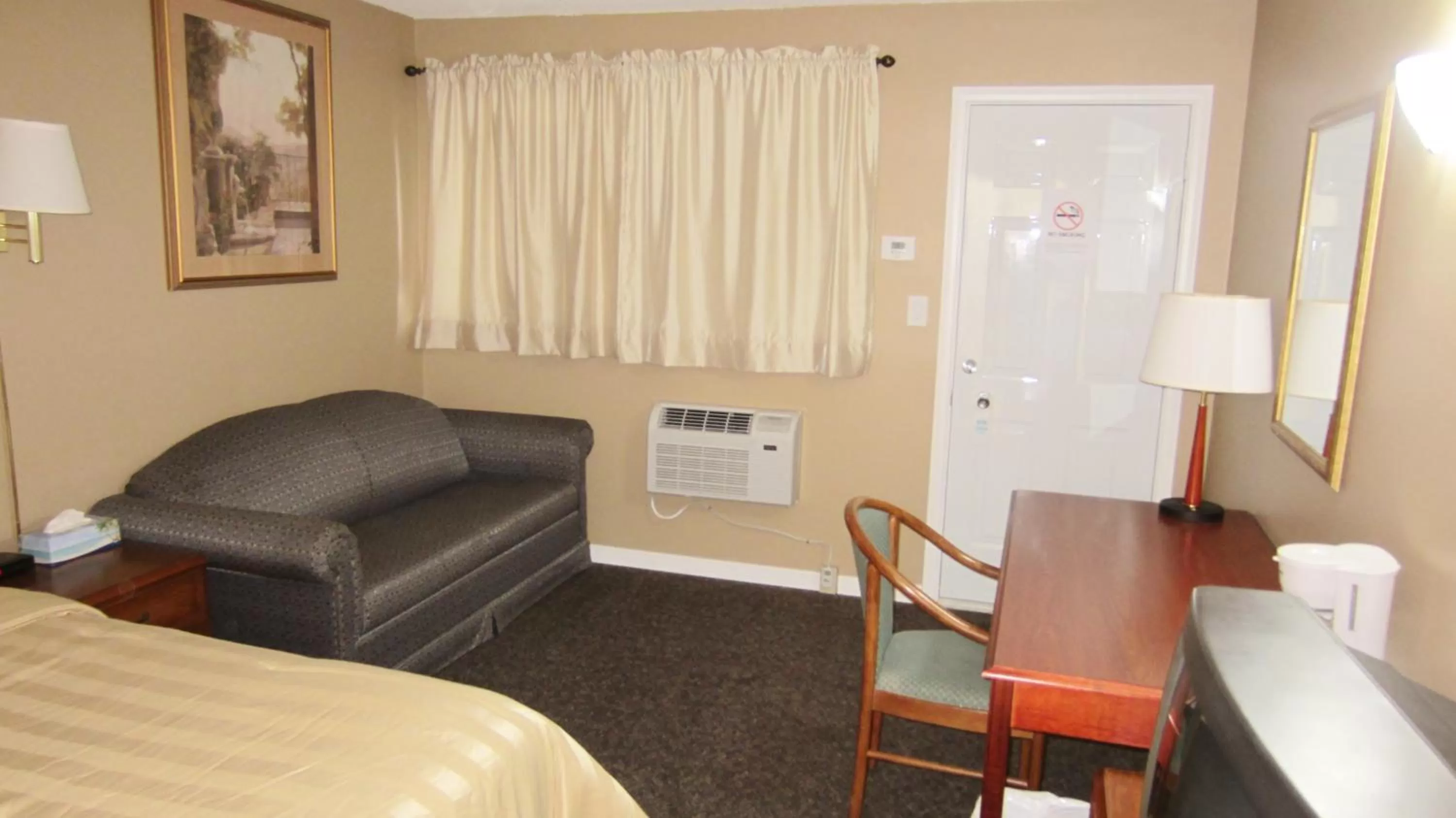 Seating area, Bed in Village Inn & Suites - Sudbury